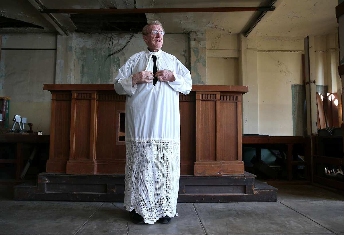 Jesuit priest Fr. Bernie Bush dons an alb, part of which was crocheted by former prisoner Lawrence Trumblay, while visiting the old cell house chapel on Alcatraz in San Francisco, Calif. on Wednesday, Feb. 25, 2015. Father Bush regularly visited the former federal penitentiary for several years while he was studying in the priesthood in the 1960's and became close friends with convicted bank robber Lawrence Trumblay.