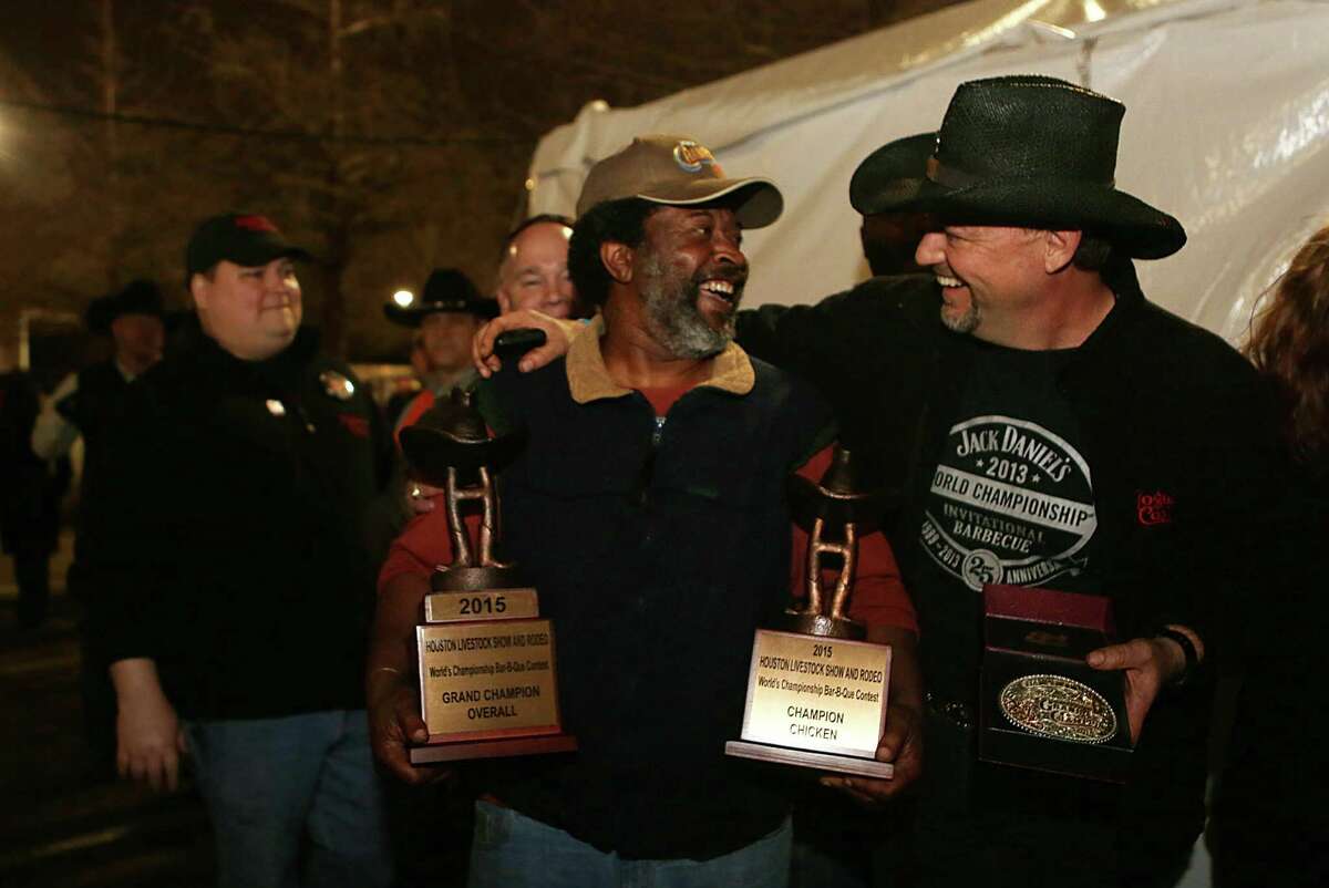 Teammates Kerry Fellows and Doug Scheiding carry the trophy awarded to Across the Track Cook-Off Team for the 2015 Houston Livestock Show and Rodeo World's Champion Bar-B-Que Cookoff Grand Champion Overall on Saturday, Feb. 28, 2015, in Houston.