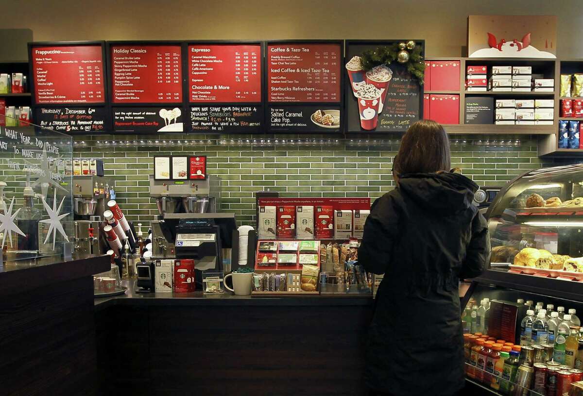 A customer places an order at a Starbucks in Chicago. Areas by cash registers are often crowded with little extras in part because the closer a customer is to an item, the more likely they are to make an impulse buy. (