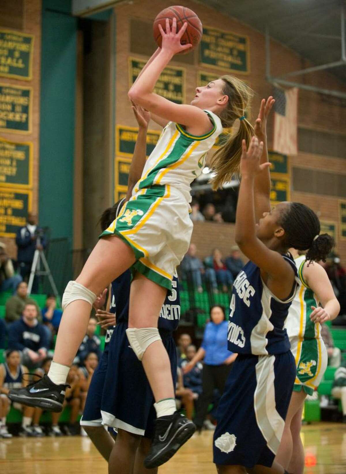 Trinity's Mackenzie Griffin, left, shoots over Hillhouse's Janaya Bradley, right, during the second round of the girls CIAC basketball tournament at Trinity Catholic High School in Stamford, Conn. on Thursday, March 4, 2010. Trinity lost to Hillhouse 61-46.