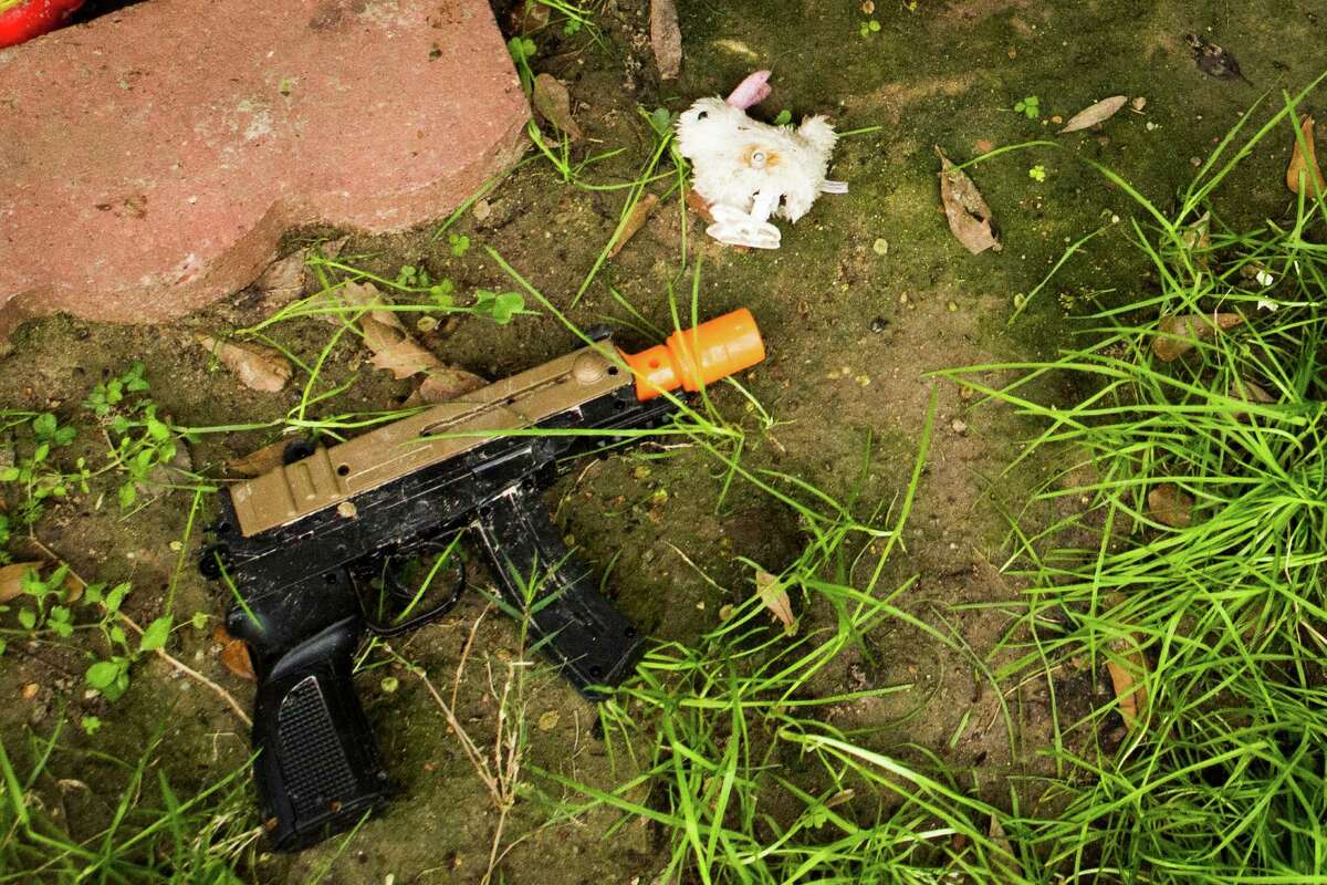 A toy gun is on the front yard of a home where a 6-year-old boy was shot by his brother, Monday, March 2, 2015, in North East Harris County.