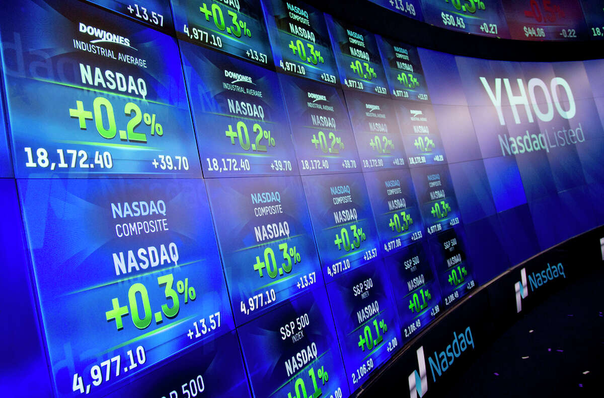 Electronic screens in New York reflect the value of the Nasdaq composite index as it approached 5,000 on Monday.