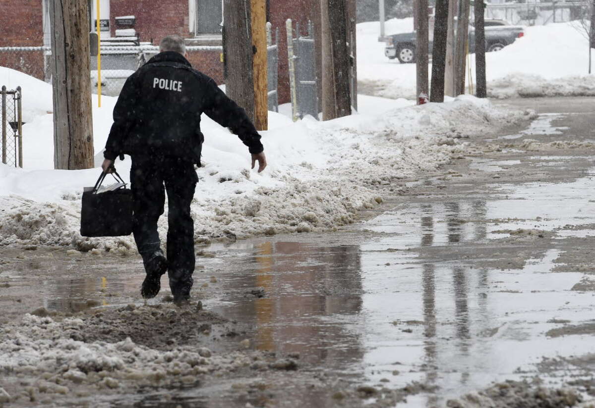 A Cohoes police officer walks through water on Canvas Street at the rear of City Hall after a water main break caused flooding Monday morning, Feb. 9, 2015, in Cohoes, N.Y. (Skip Dickstein/Times Union)