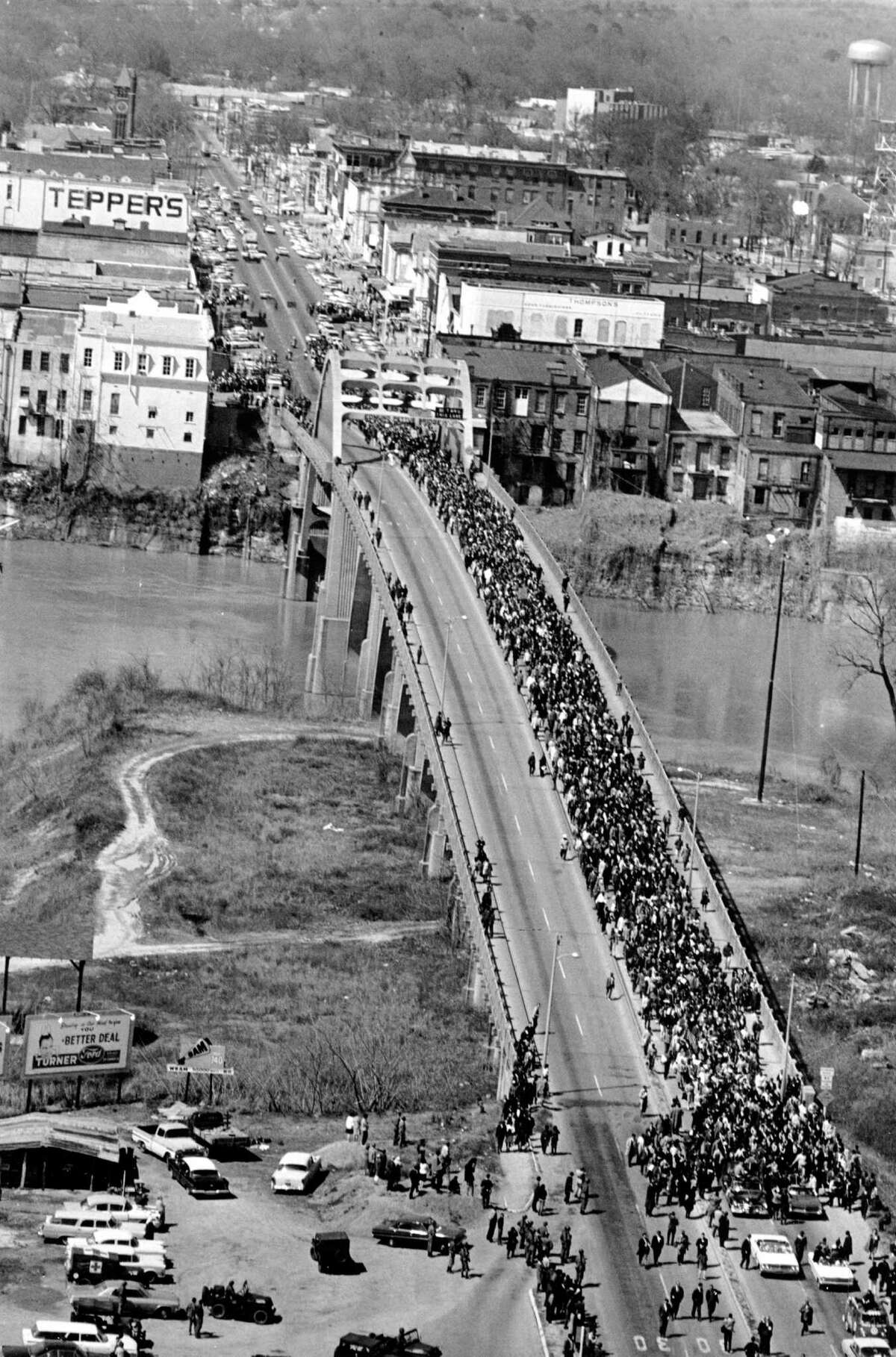 FILE - In this March 21, 1965 file photo, civil rights marchers cross the Alabama river on the Edmund Pettus Bridge in Selma, Ala. to the State Capitol of Montgomery. The Edmund Pettus Bridge gained instant immortality as a civil rights landmark when white police beat demonstrators marching for black voting rights 50 years ago this week in Selma, Alabama. Whatâs less known is that the bridge is named for a reputed leader of the early Ku Klux Klan. Now, a student group wants to rename the bridge that will be the backdrop when President Barack Obama visits Selma on March 7, 2015. (AP Photo/File)