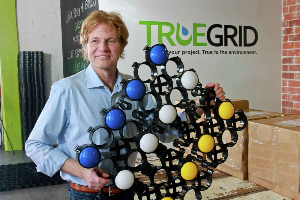 Barry Stiles, founder and CEO of Truegrid, holds a permeable paver with snap-in color parking markers.