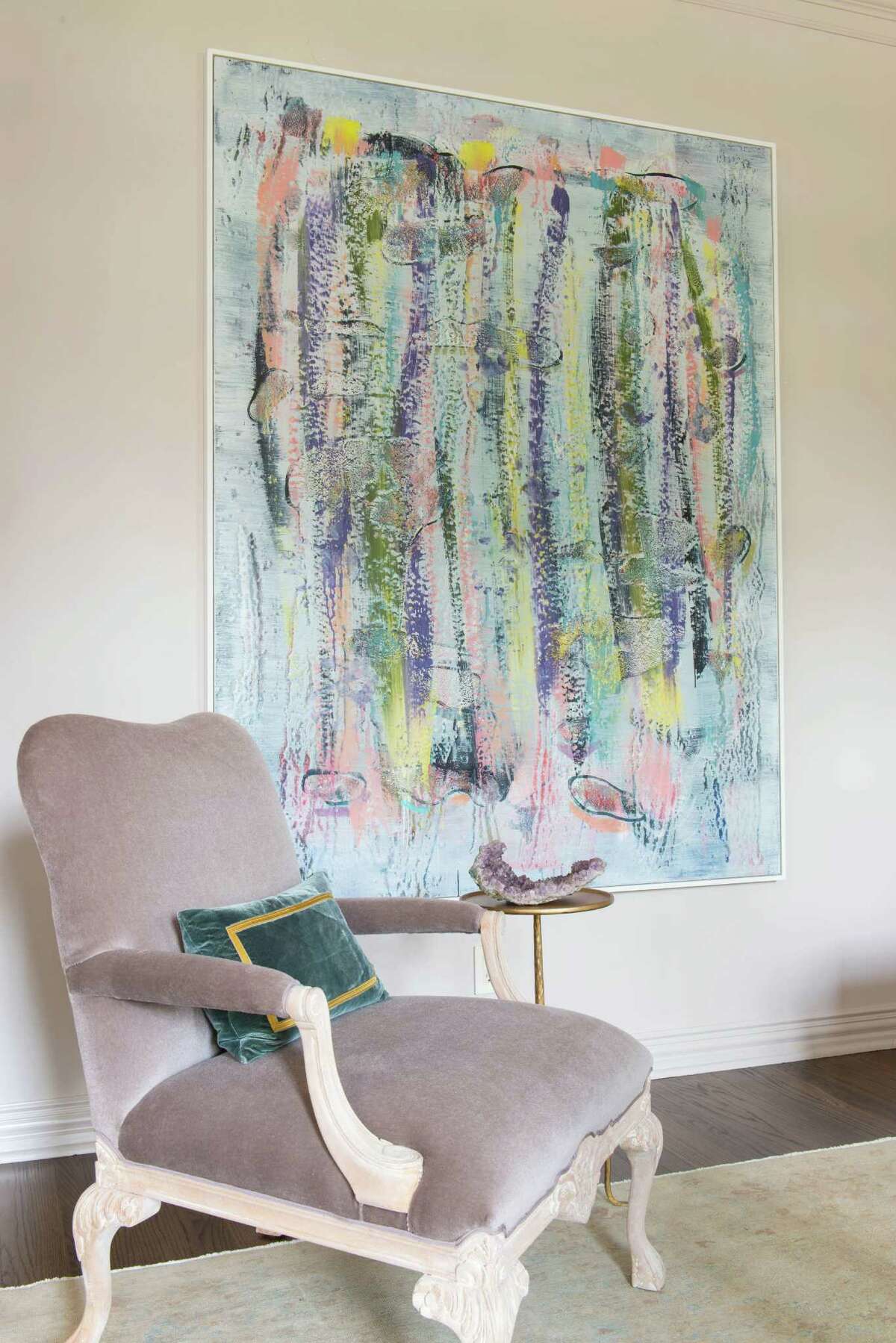 A painting by Jon Pestoni dominates one wall of the formal sitting room, adding a pop of color that coordinates with the room's pale neutrals.