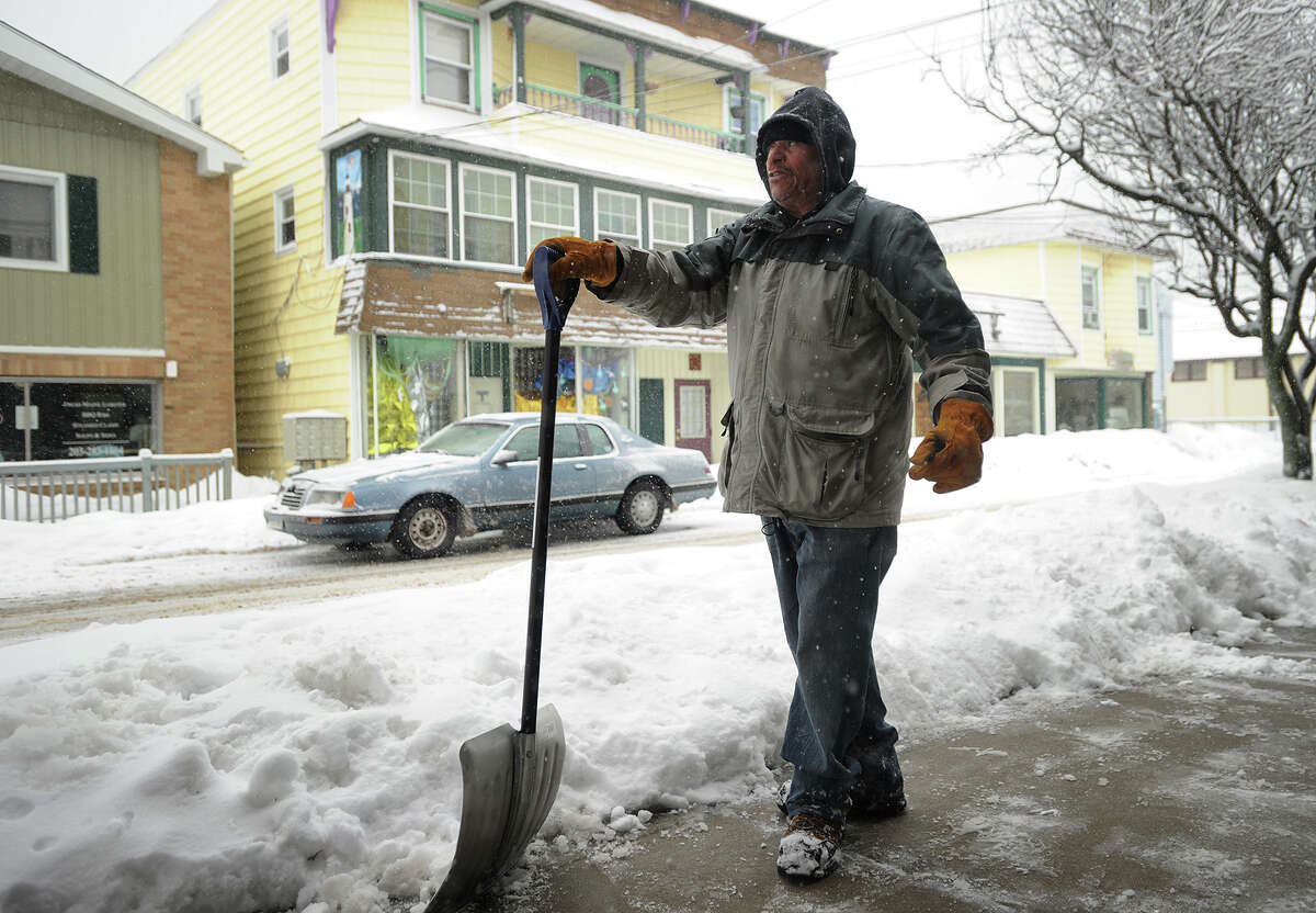Eliezer Ledesma shovels the sidewalks in front of businesses on Broadway in the Walnut Beach section of Milford, Conn. on Thursday, March 5, 2015.