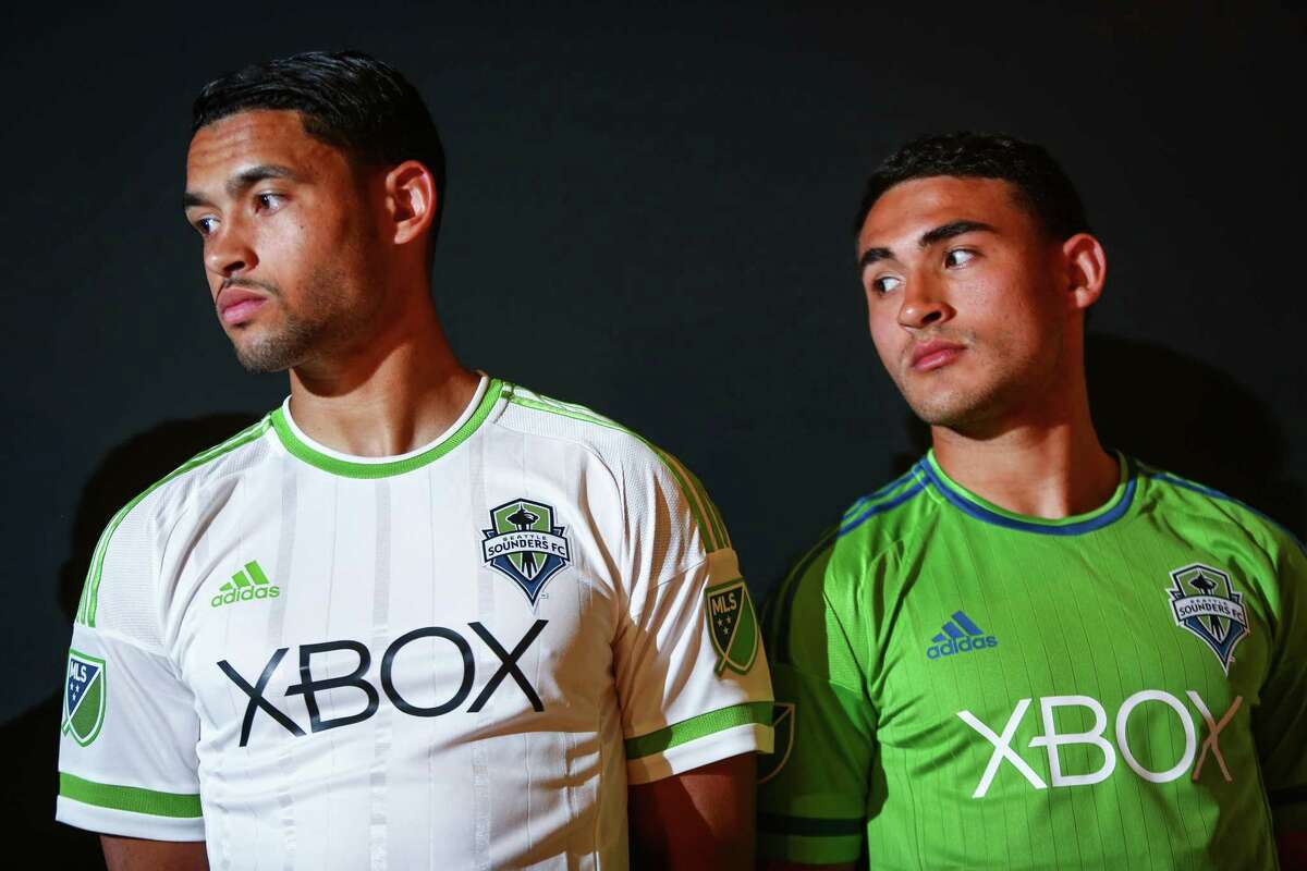 Seattle Sounders players Lamar Neagle and Cristian Roldan show the new Seattle Sounders uniforms during an unveiling at "THE NINETY," the Sounders' front office and event space in Pioneer Square on Thursday, March 5, 2015.