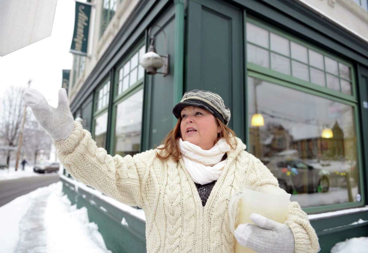 Cafe Atlantique owner Tina Roberts talks about Milford's plans to tear down a plaza across the street to provide downtown parking on River Street in Milford, Conn. Thursday, Mar. 5, 2015.