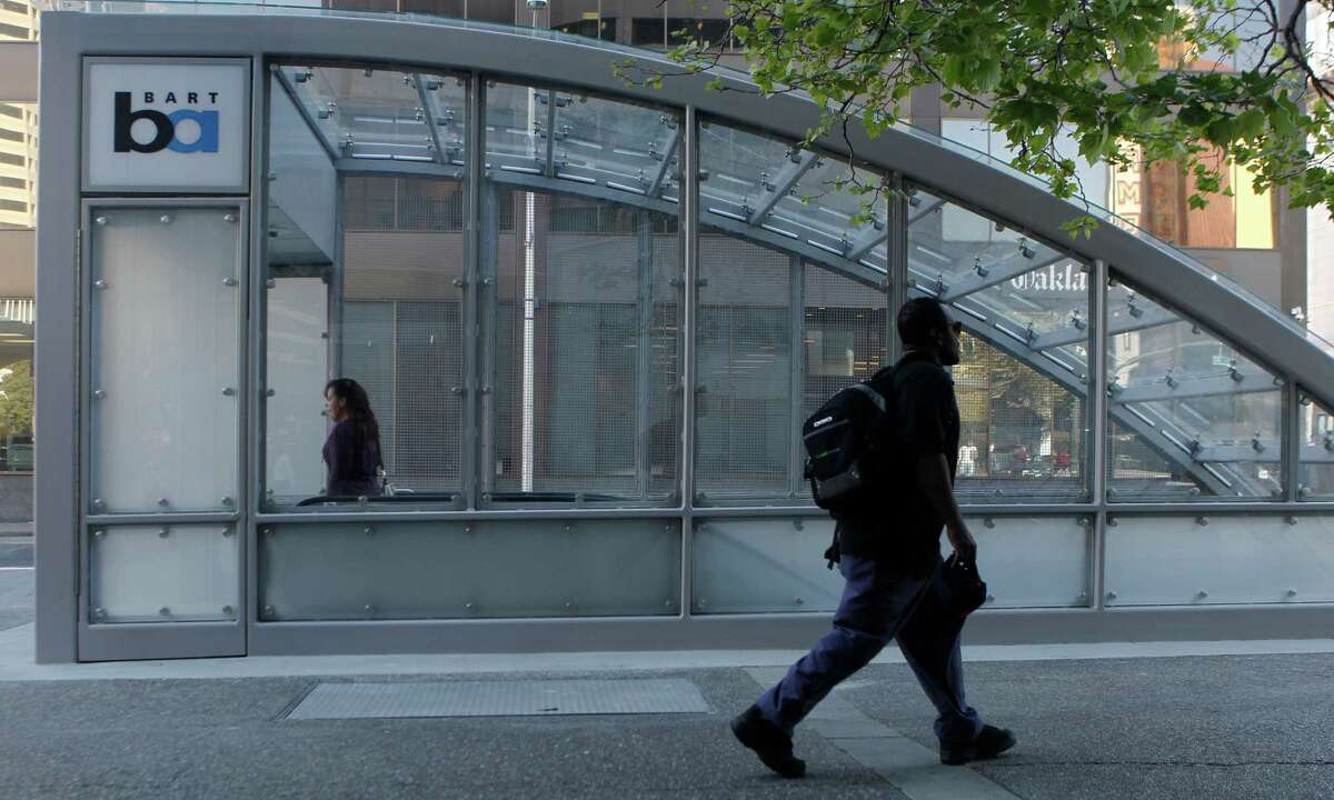 A commuter descends into the 19th Street BART Station in Oakland under the new entrance canopy.