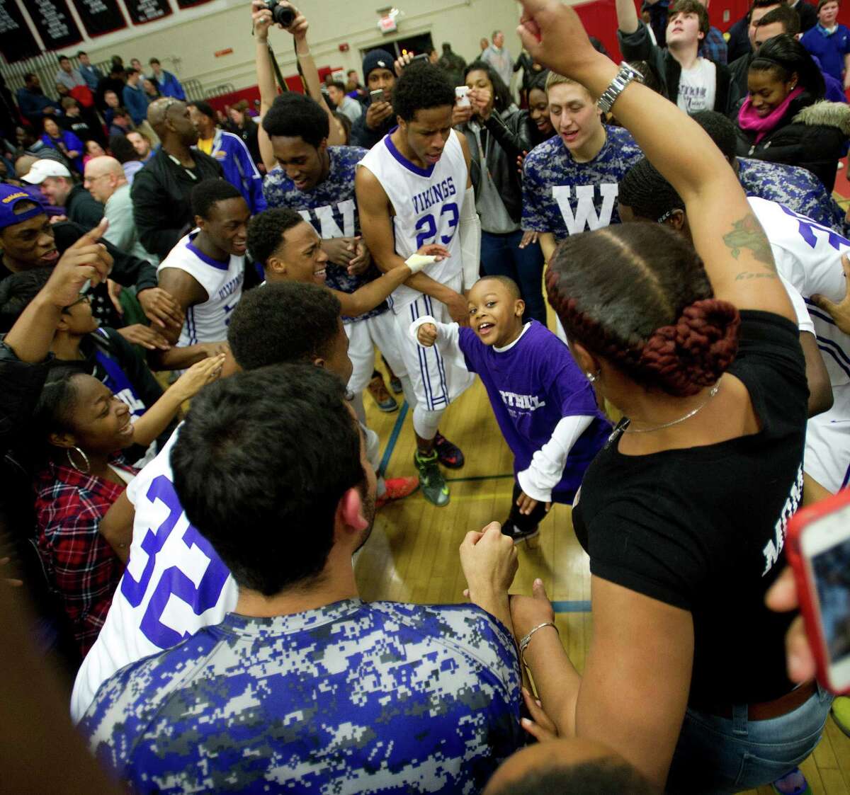 Westhill players surround Raheem Hargrove-Murray, 7, as they dance to celebrate winning Friday's FCIAC Boys Basketball Championship game between Westhill and Norwalk High Schools at Fairfield Warde High School in Fairfield, Conn., on Friday, March 6, 2015.