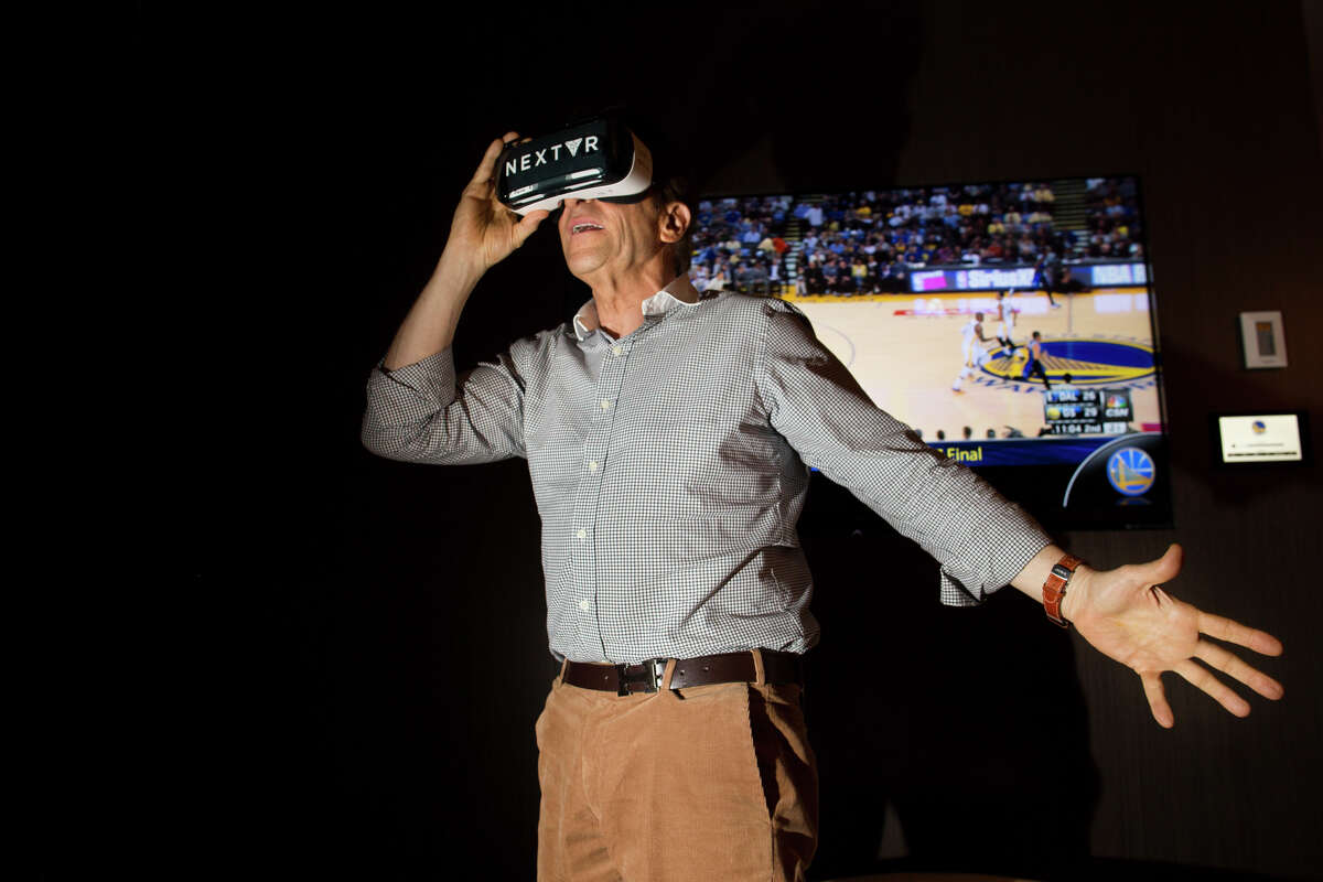 Warriors co-owner Peter Guber watches his team through the NextVR virtual reality glasses, which can put fans right next to the action, even if they don’t have a prime seat like Weston Stankowski of San Francisco, below.