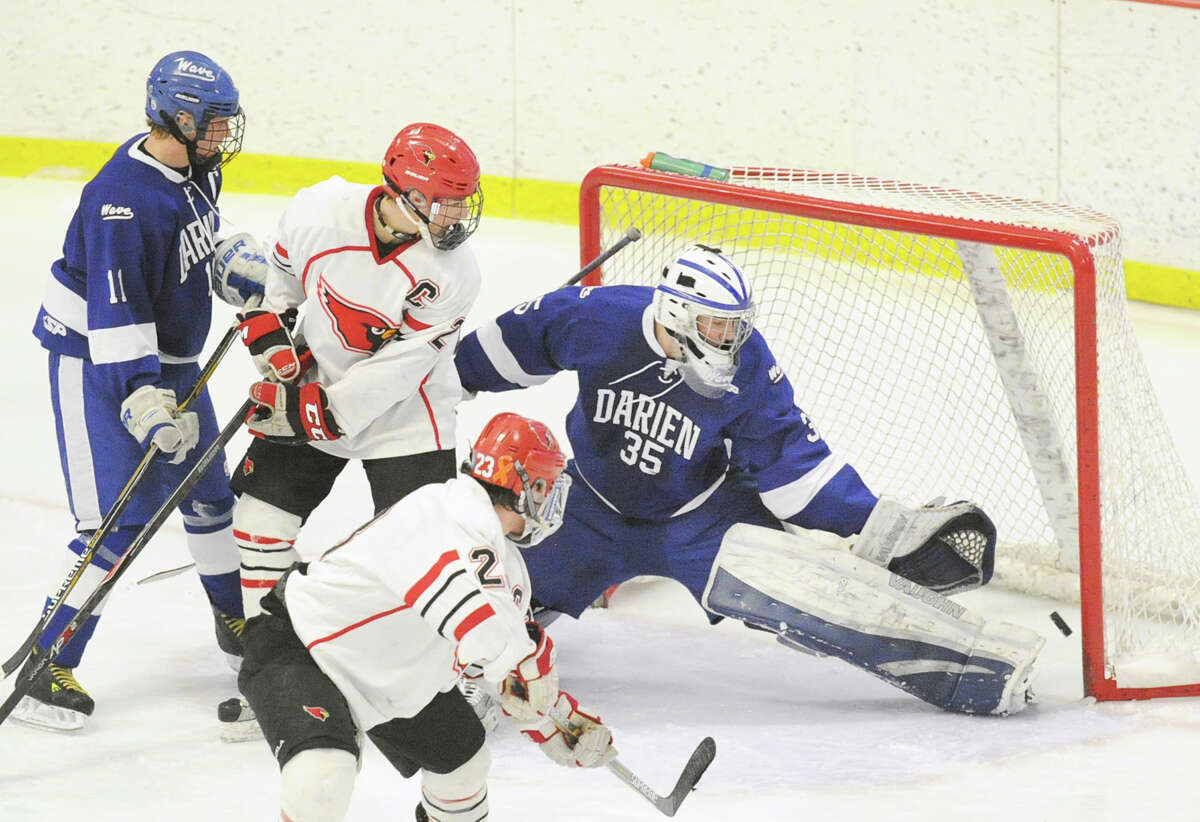 At right, Darien goaltender Will Massie makes a stop on a shot by Kevin Piotzkowski (#2) of Greenwich, bottom, as Matt Lodato, center, also of Greenwich, looks on while being defended by Nicholas Tuzinkiewicz (#11) of Darien during the FCIAC boys hockey championship game between Greenwich High School and Darien High School at Terry Conners Rink in Stamford, Conn., Saturday, March 7, 2015. Massie was named MVP of the game as Darien took the championship with a 5-3 victory.