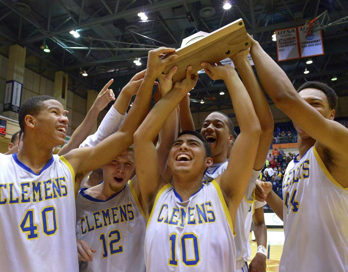 Clemens basketball team members hold up their trophy after defeating Laredo Alexander for the Region IV-6A championship at the UTSA Convocation Center on March 7, 2015.