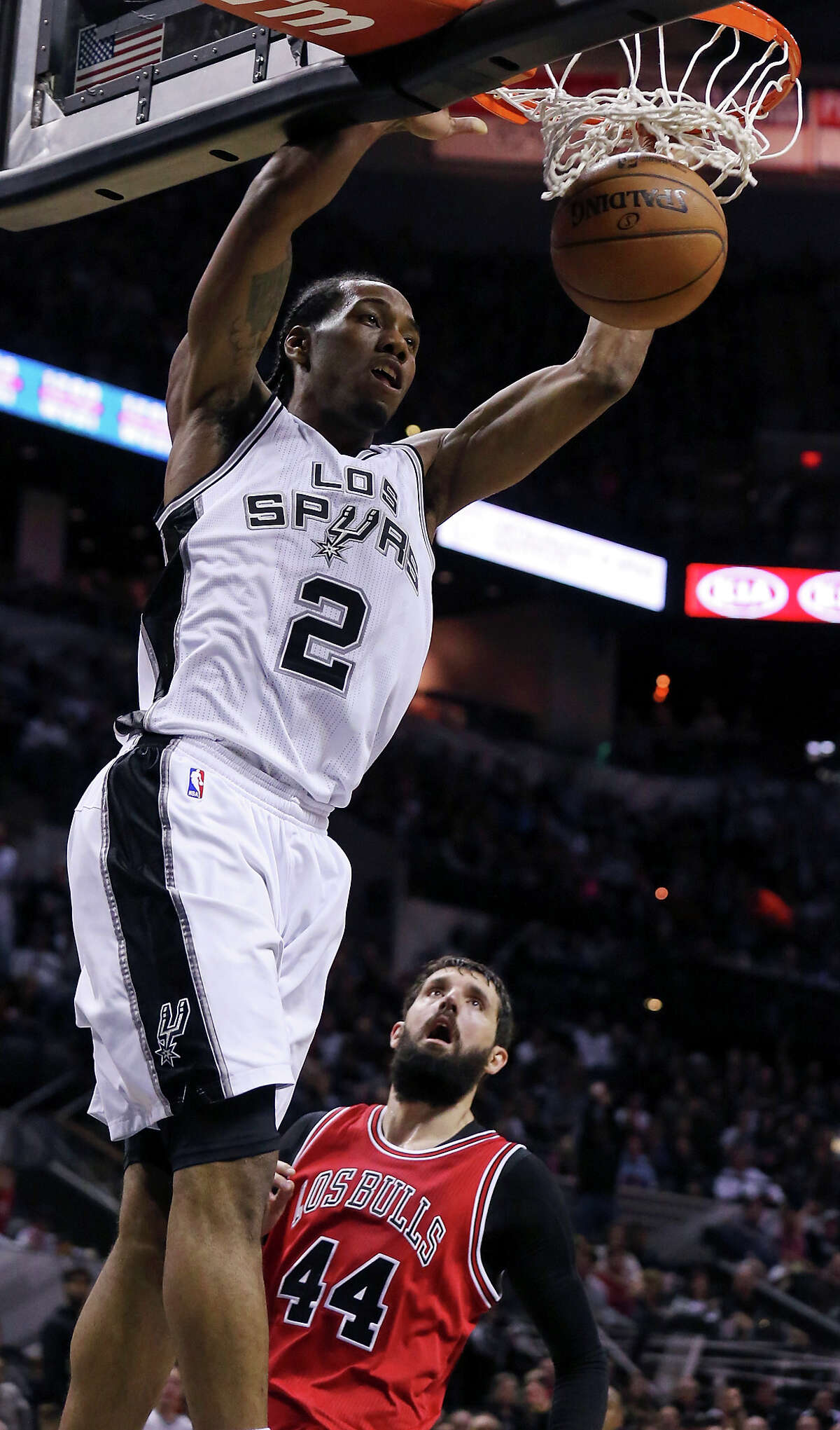 San Antonio Spurs' Kawhi Leonard dunks ahead of Chicago Bulls' Nikola Mirotic during first half action Sunday March 8, 2015 at the AT&T Center.