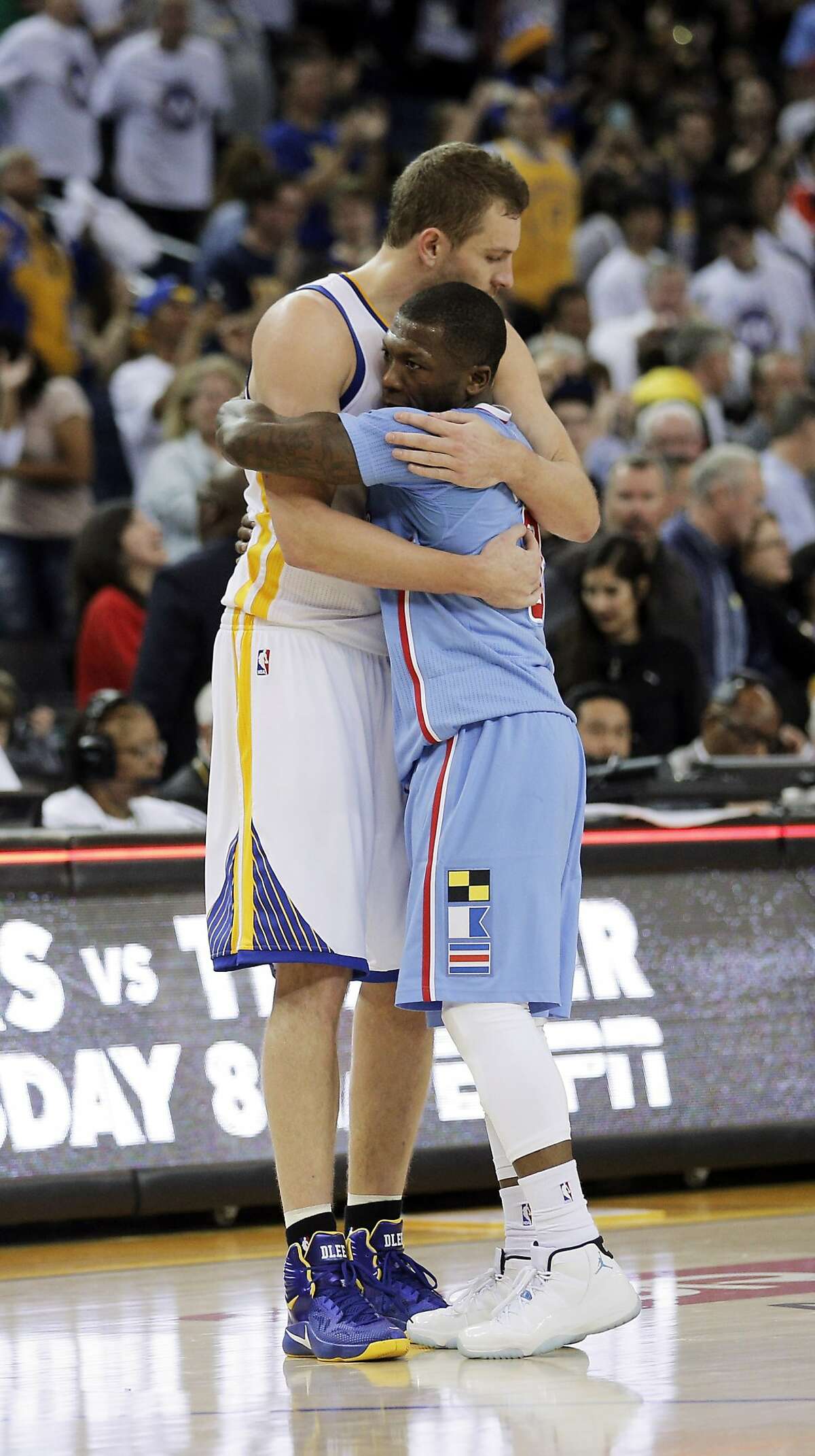 David Lee (10) hugs Nate Robinson (8) after the Warriors defeated the Clippers 106-98. The Golden State Warriors played the Los Angeles Clippers at Oracle Arena in Oakland, Calif., on Sunday, March 8, 2015.