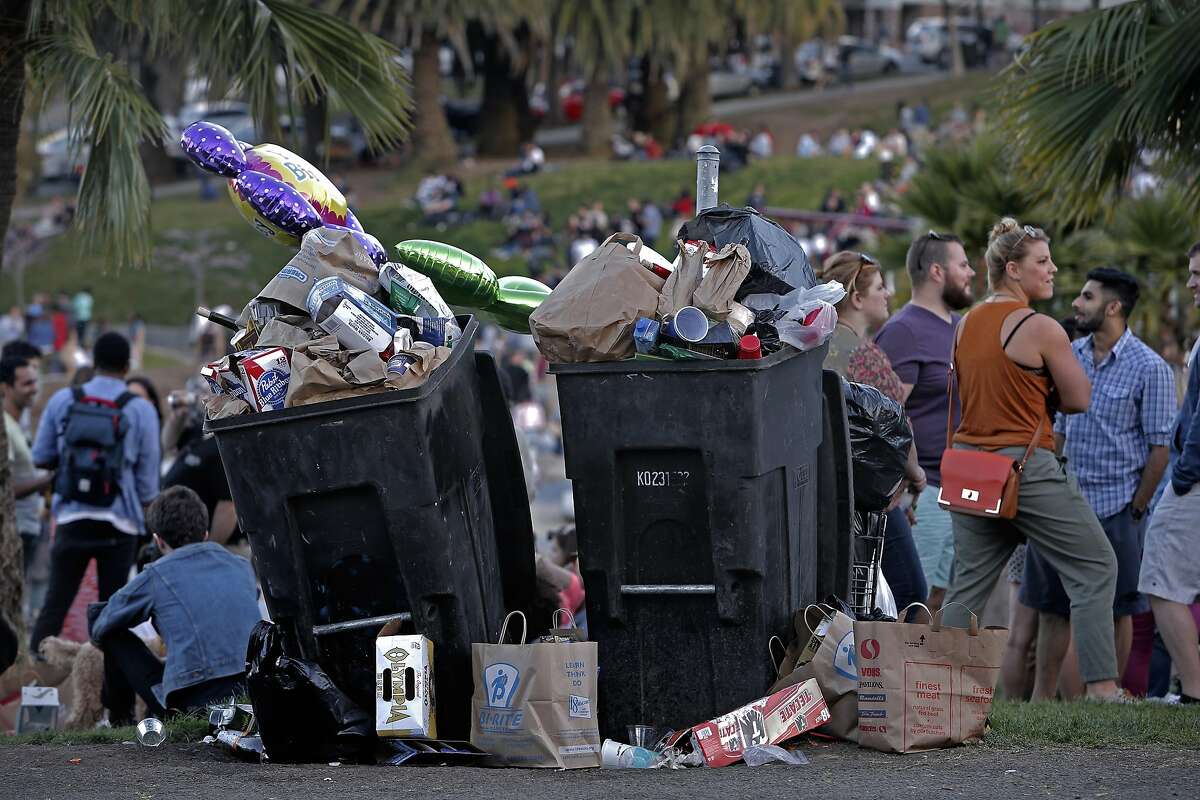 Trash cans are filled to the brim with trash in the late afternoon, at Dolores Park on Sat. March 7, 2015.