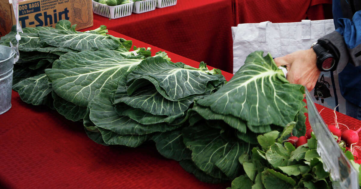 Rafael Paredes buys some of the collard greens available at the Kubena Farms booth at the Yard Farmers and Ranchers Market off of McCullough Avenue.
