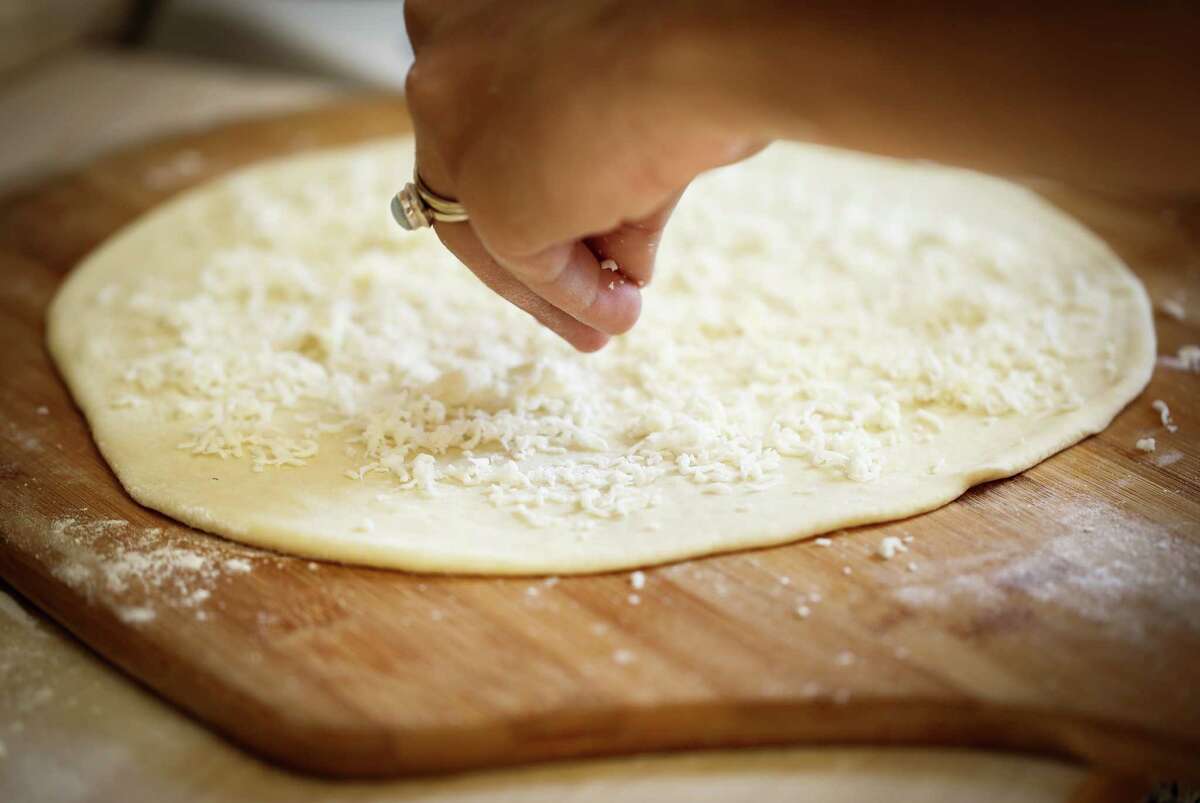 Reem Assil spreads a bit of ackawi cheese on dough to make man’oushe.