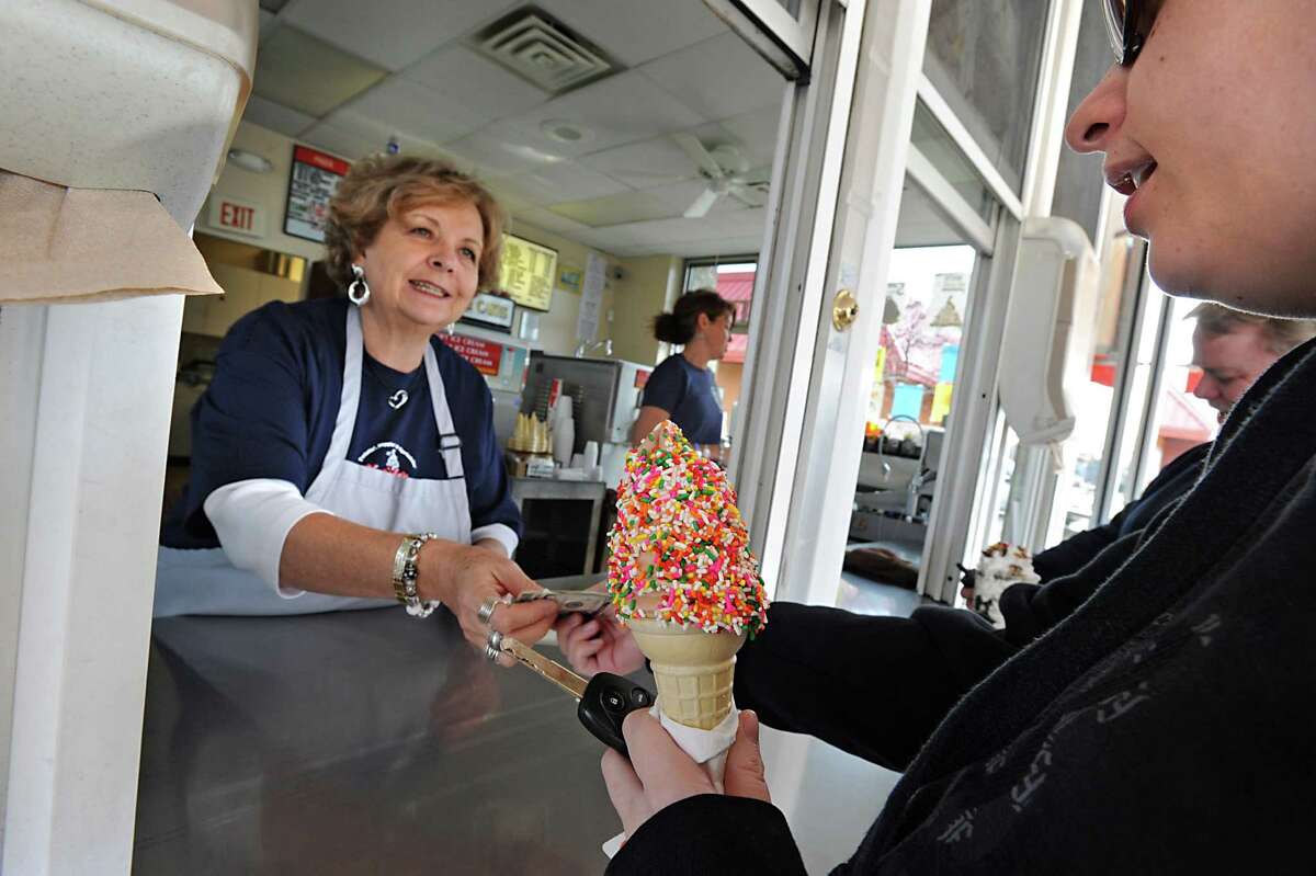 Kurver Kreme owner Lorie Meineker hands an ice cream cone to customer Dina Vause, of Colonie, on their first opening day of the season in Colonie, NY on March 17, 2011. (Lori Van Buren / Times Union)