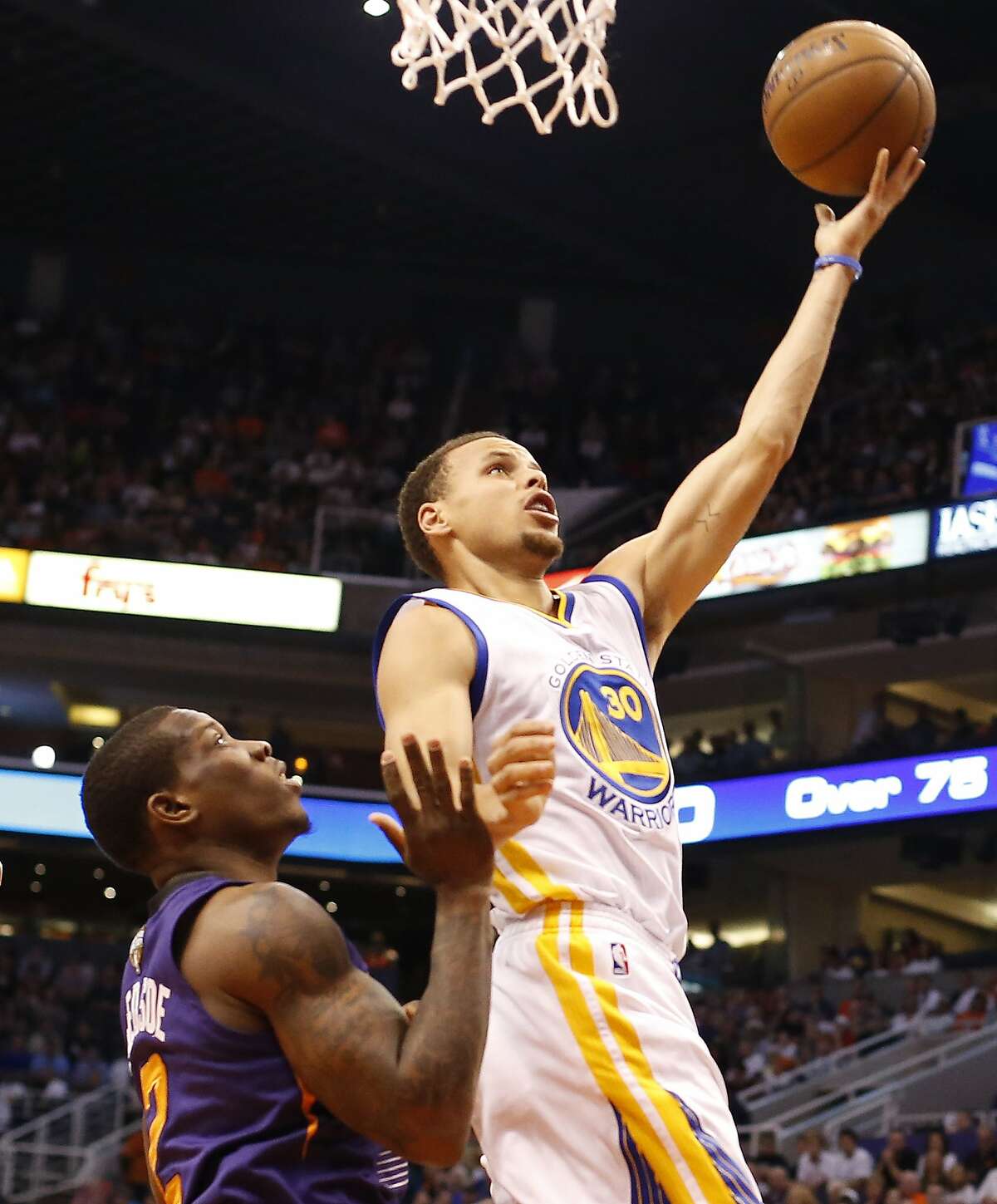 Golden State Warriors guard Stephen Curry (30) shoots over Phoenix Suns guard Eric Bledsoe (2) in the second quarter during an NBA basketball game, Monday, March 9, 2015, in Phoenix. (AP Photo/Rick Scuteri)
