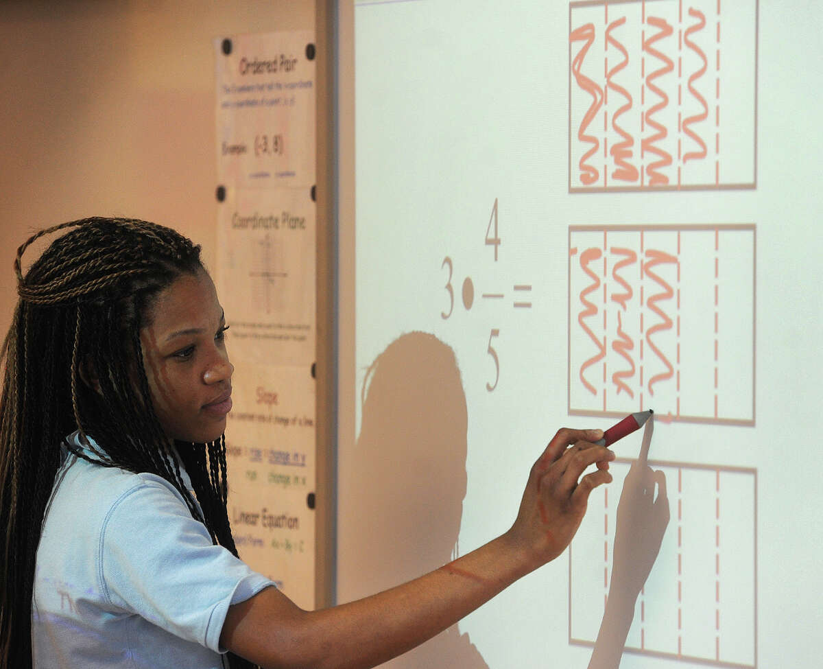 Eighth grader Judi-Ann Freemantle, 13, works out a fraction multiplication problem using an area model at Jettie Tisdale School in Bridgeport, Conn. on Tuesday, March 10, 2015.