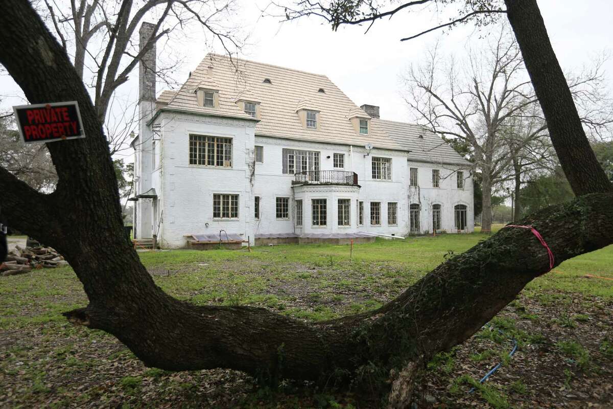 An old oak tree frames the Weingarten Mansion from the south side of the property in Riverside Terrace on Friday, Feb. 27, 2015, in Houston. ( Mayra Beltran / Houston Chronicle )