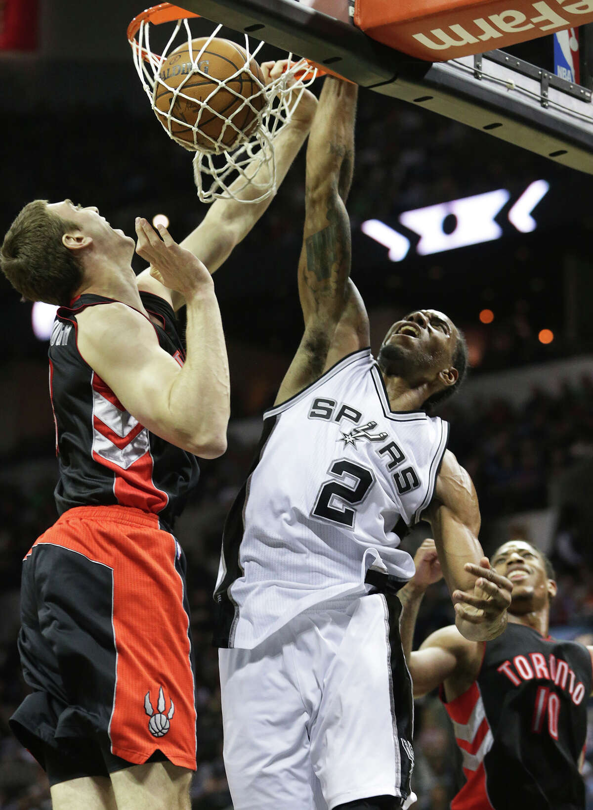 Kawhi Leonard jams a shot down against Tyler Hansbrough in the second half as the Spurs host the Toronto Raptors at the AT&T Center on March 10, 2015.