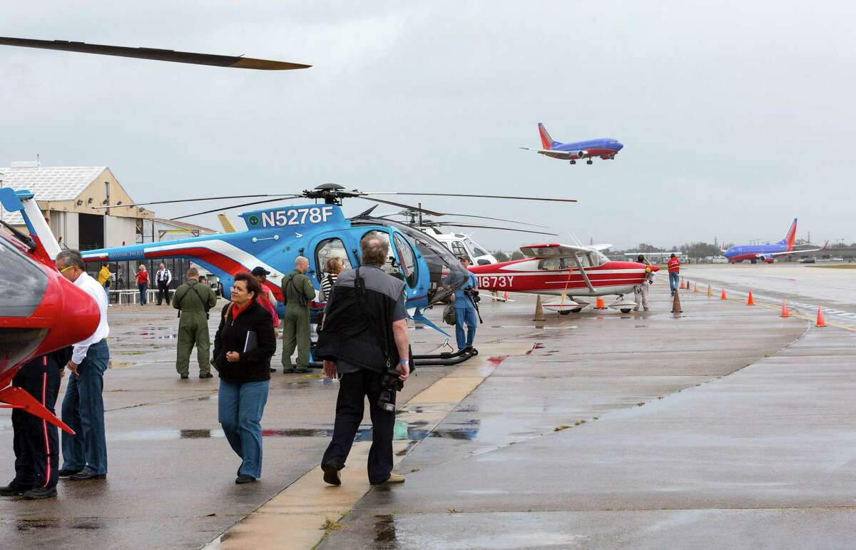 Despite the on again/off again weather, fans of flight explore the helicopters and flight museum during "Wings & Wheels Chopper Day" at the 1940 Air Terminal Museum, 8325 Travelair Street at Hobby Airport. ID: Southwest Airline traffic buzzes along normally near the helicopter display. Saturday February 21, 2015 (Craig H. Hartley/For the Chronicle)