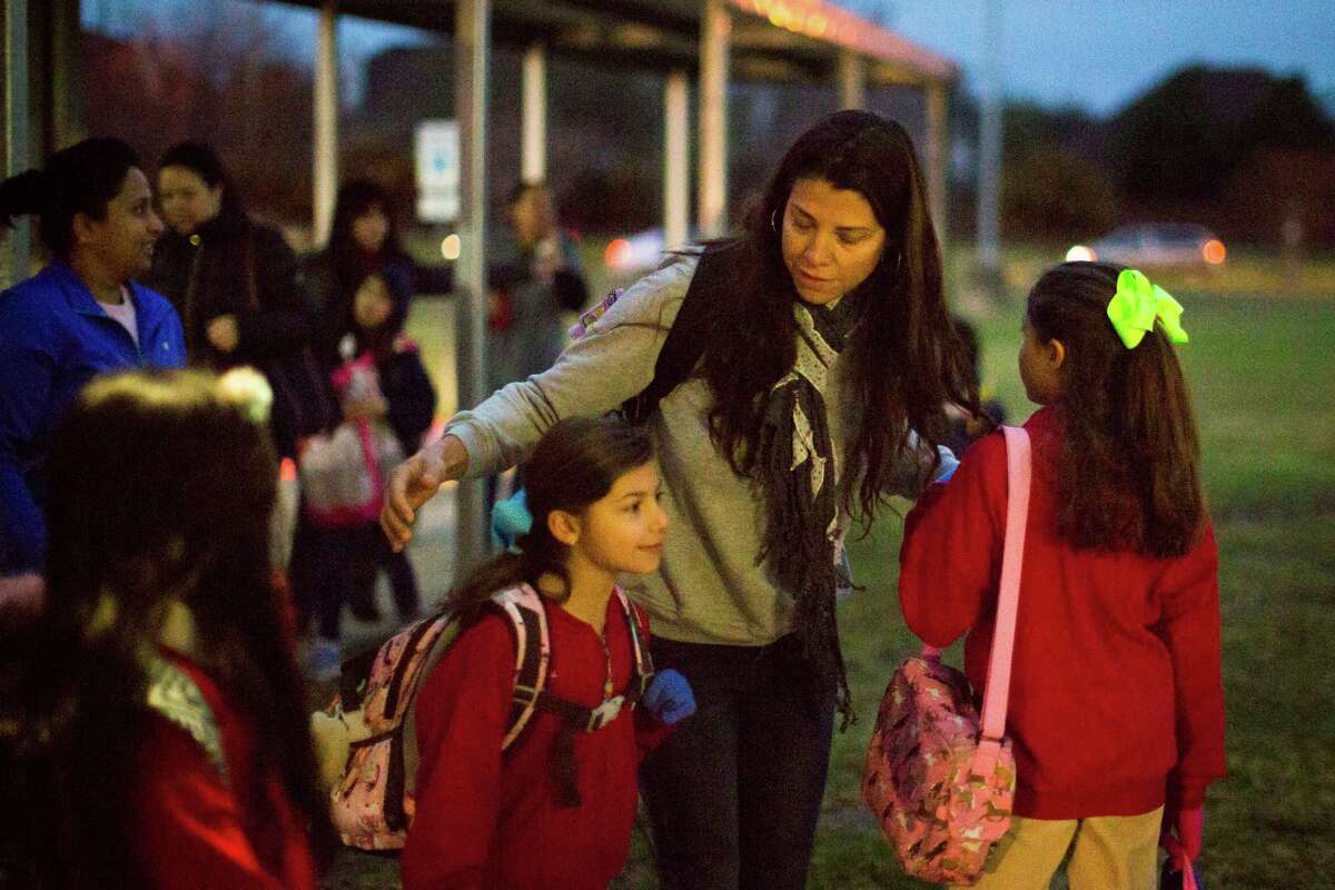 Alexandra Erkal, says good bye to her daughters Alexa Erkal, 8, and Andrea Erkal, 10, after walking them to the Barbara Bush Elementary School along with other neighborhood children who study at the same school. Wednesday, March 11, 2015, in Houston.