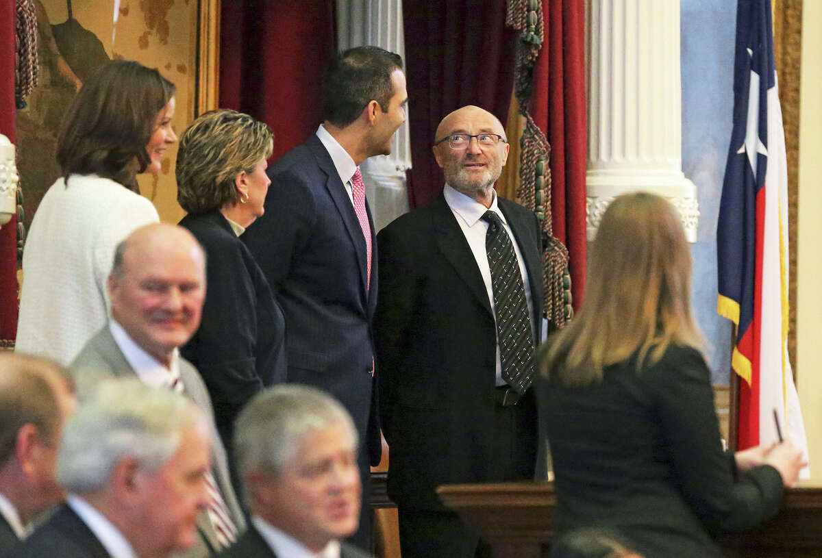 Phil Collins glances at Land Commissioner George P. Bush while he is recognized in the HOuse of Representatives as an honorary Texan March 11, 2015.