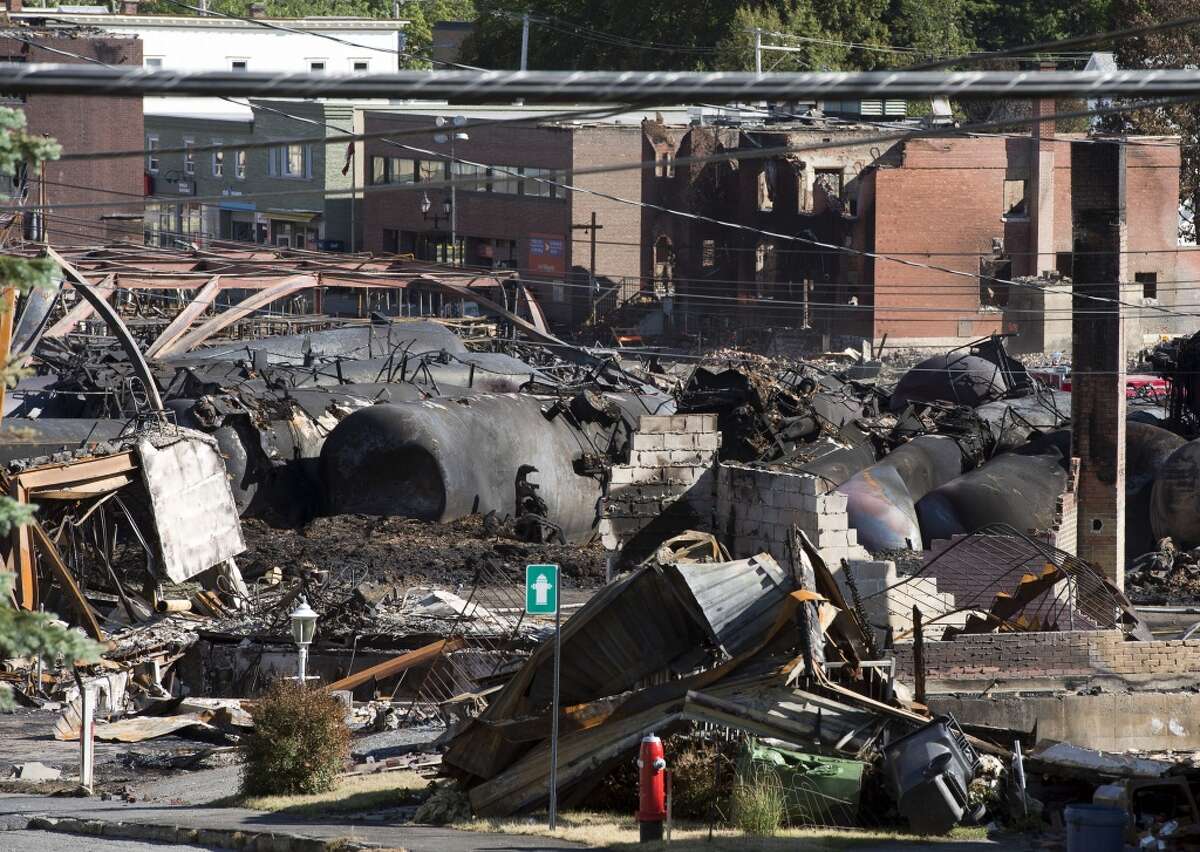 The downtown core lies in ruins Thursday, July 11, 2013 in Lac-Megantic, Quebec, Canada. The first victim of a runaway oil train's explosive derailment in the Quebec town was identified Thursday, more than five days since the disaster, which left behind a scorched scene so dangerous that it slowed the search for 50 people presumed dead. (AP Photo/Ryan Remiorz, The Canadian Press)
