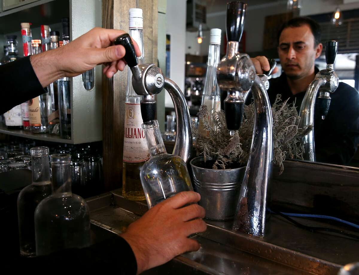 Francisco Galindo fills bottles with water at The Corner Store restaurant in San Francisco, Calif. on Thursday, March 12, 2015. Proposed statewide conservation rules would require restaurants to ask customers if they would like water before serving it.