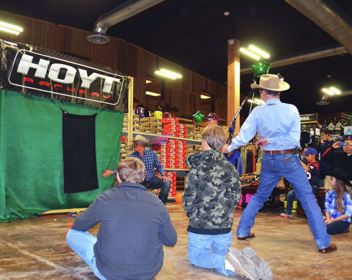 Exhibition archer Frank Addington fires three arrows from a bow held behind his back to hit three baby aspirins tossed into the air during a demonstration of extreme archery accuracy at Wheeler’s Feed and Outfitter’s in Boerne.