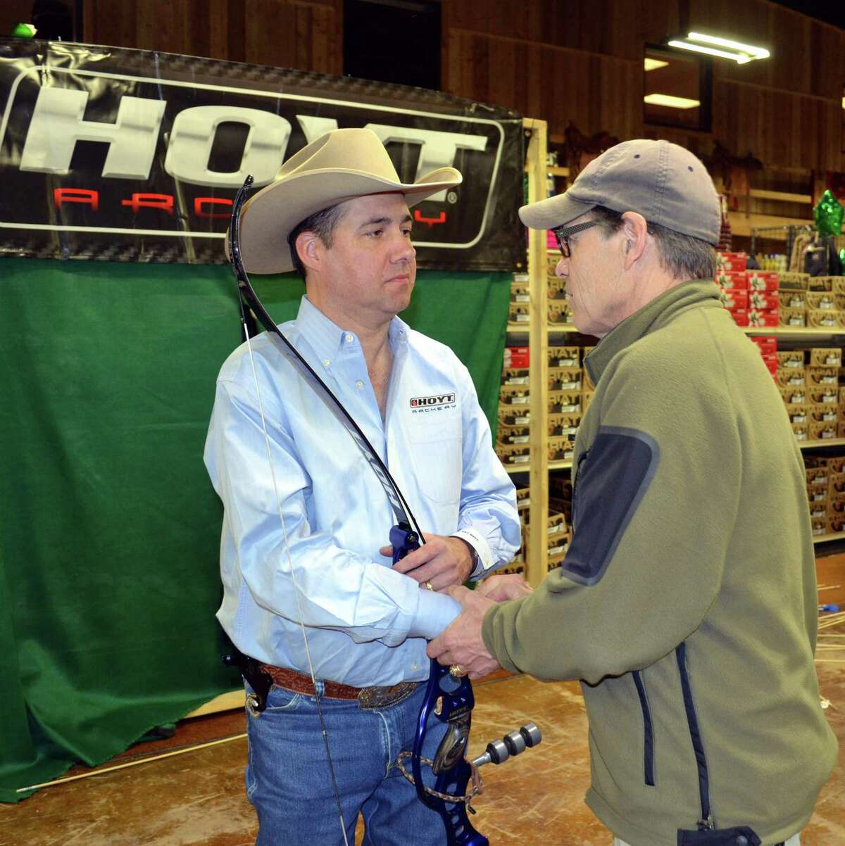 Former Gov. Rick Perry congratulates expert archer Frank Addington on his incredible skills and exchanges some bow hunting experiences with the bowman following a performance at Wheeler’s Feed and Outfitter’s in Boerne.