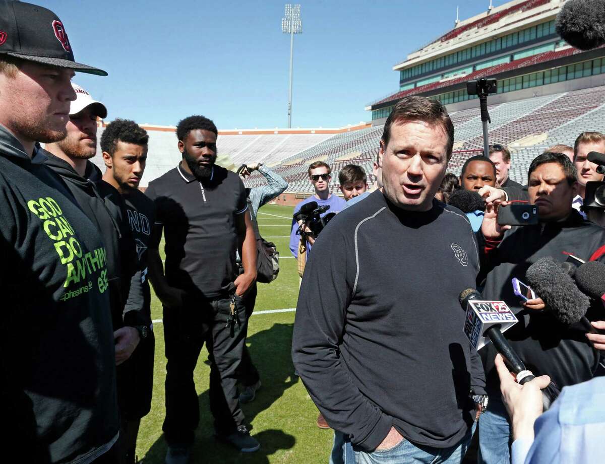 Oklahoma head coach Bob Stoops, center, answers a question for reposters following a demonstration by the Oklahoma football team against racism in Norman, Okla., Thursday, March 12, 2015. Looking on, from left, are players Ty Darlington, Trevor Knight, Zack Sanchez and Charles Tapper. (AP Photo/Sue Ogrocki) ORG XMIT: OKSO104