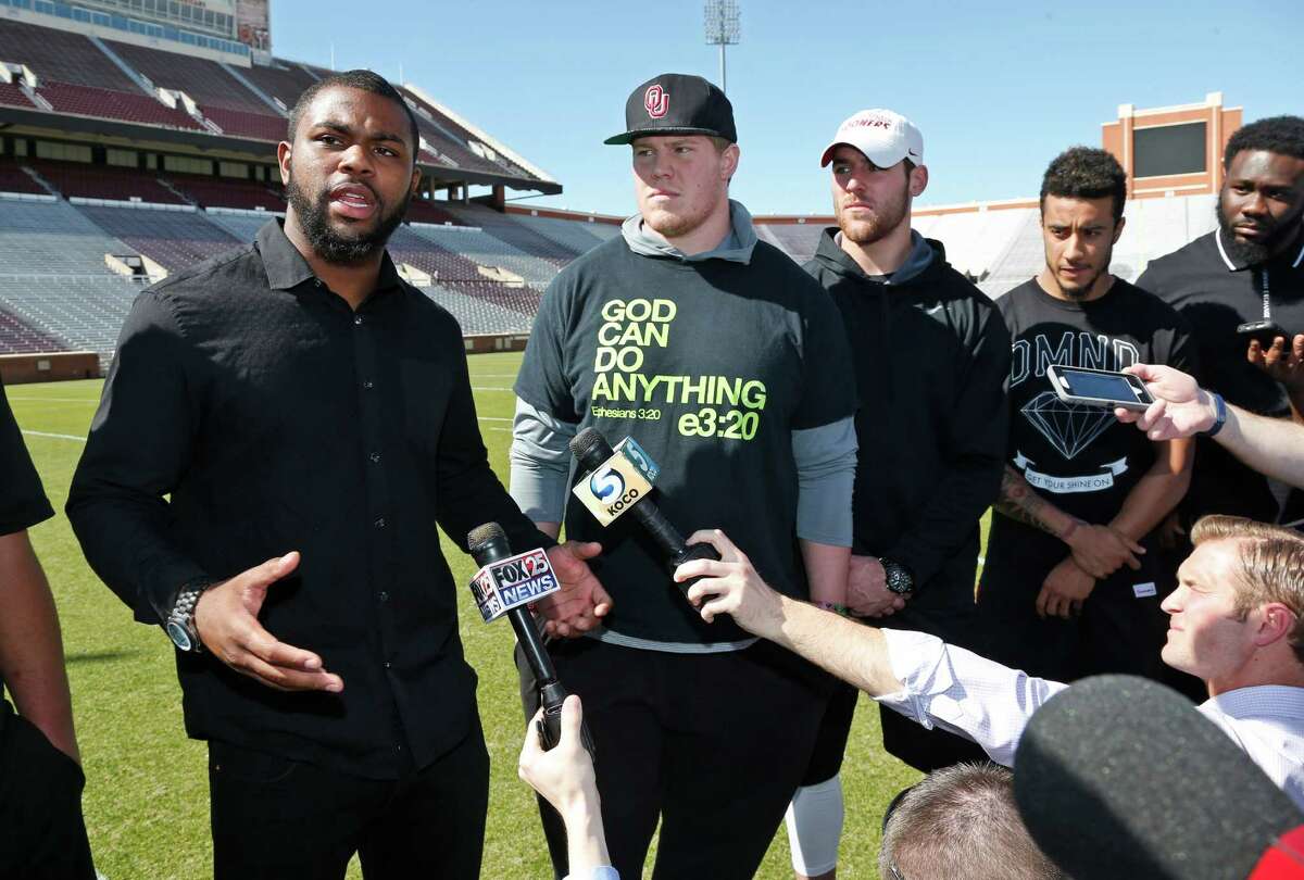 Oklahoma linebacker Eric Striker, left, gestures as he answers a question following a demonstration by the Oklahoma football team against racism, in Norman, Okla., Thursday, March 12, 2015. From left are Striker, center Ty Darlington, quarterback Trevor Knight, cornerback Zack Sanchez and defensive end Charles Tapper. (AP Photo/Sue Ogrocki) ORG XMIT: OKSO103