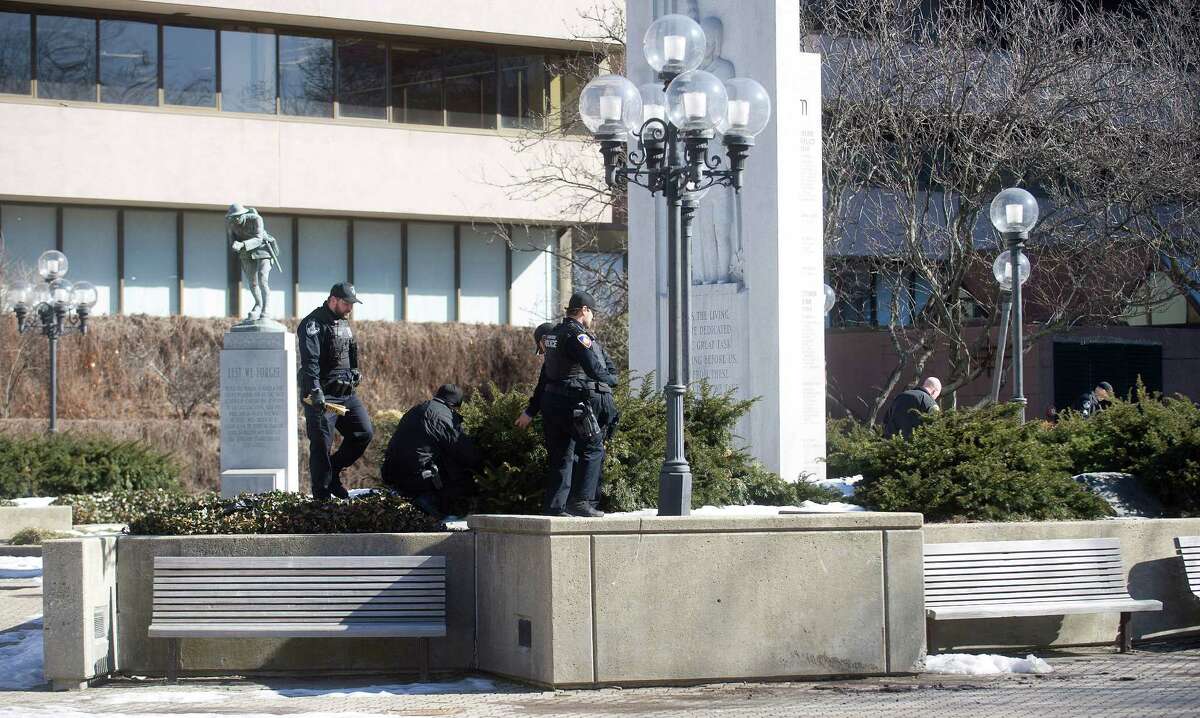 Stamford police officers search Veteran's Park in Stamford, Conn., on Thursday, March 12, 2015, after Antonio Muralles was murdered after he was stabbed, beaten and robbed Wednesday night.