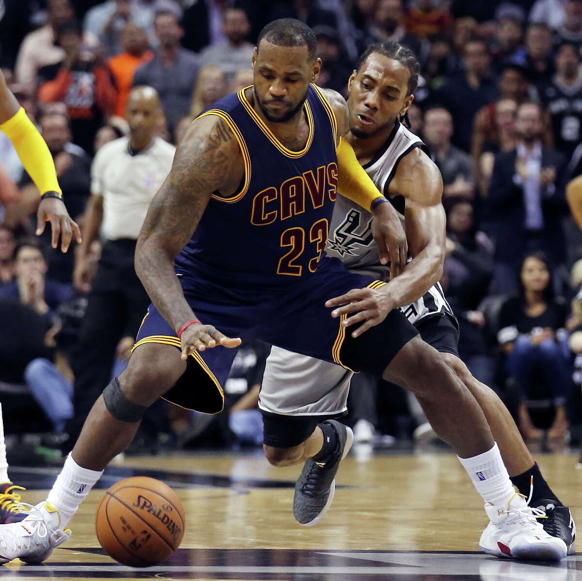 Cleveland Cavaliers’ LeBron James looks for room around the Spurs’ Kawhi Leonard during overtime action on March 12, 2015 at the AT&T Center. The Cavaliers won in overtime 128-125.