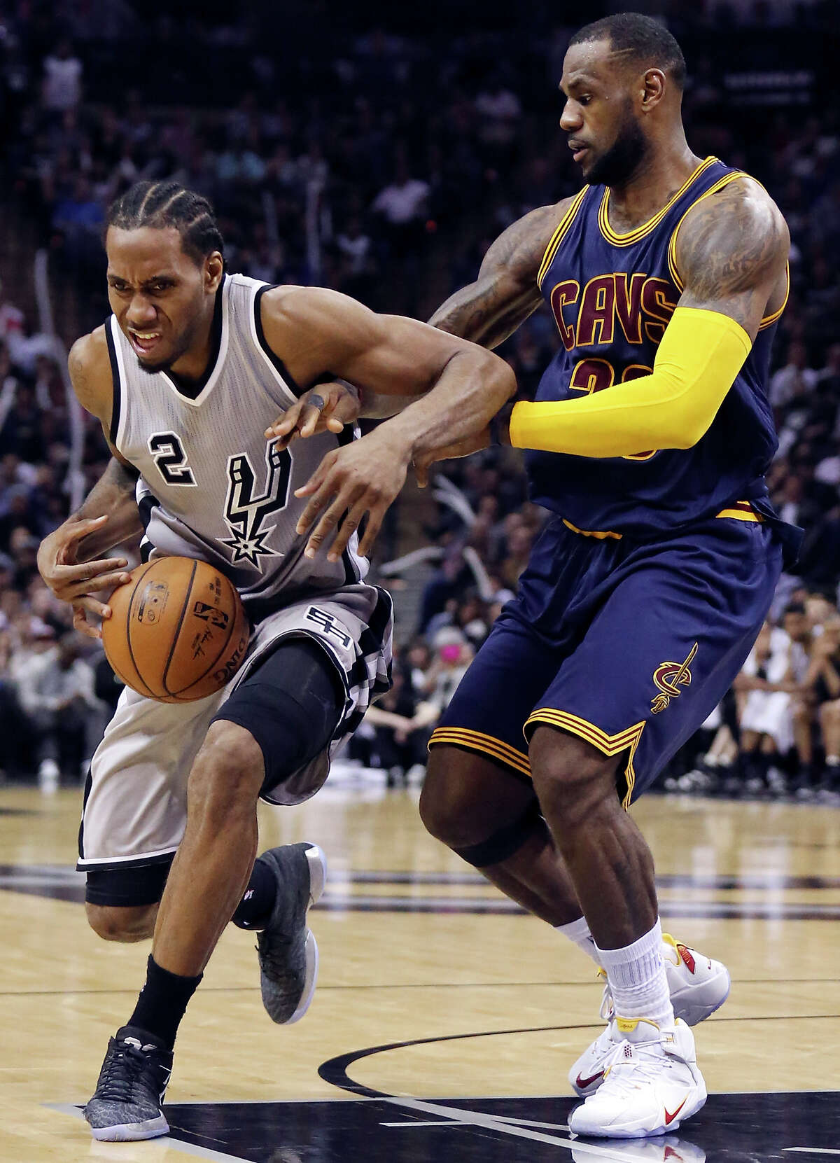 Spurs’ Kawhi Leonard looks for room around Cleveland Cavaliers’ LeBron James during their game March 12, 2015 at the AT&T Center.