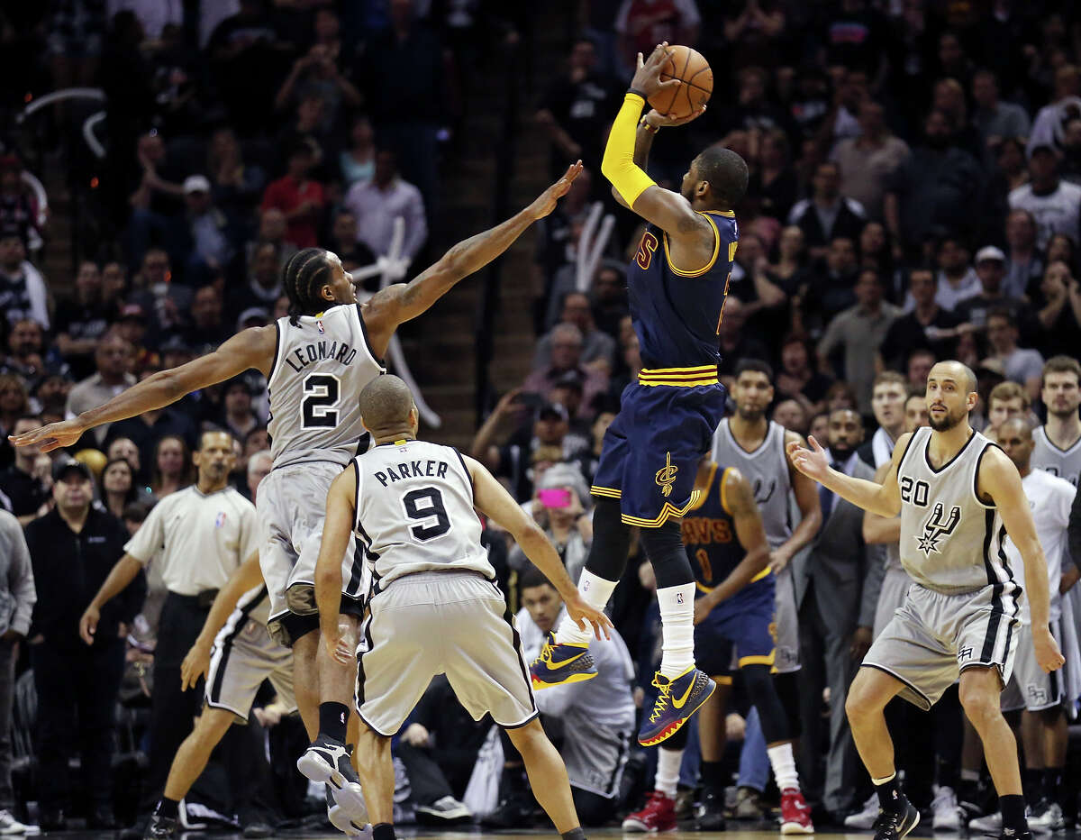 Cavaliers’ Kyrie Irving shoots a 3-pointer over the Spurs’ Kawhi Leonard as Tony Parker and Manu Ginobili look on late in second half action to send the game to overtime on March 12, 2015 at the AT&T Center.