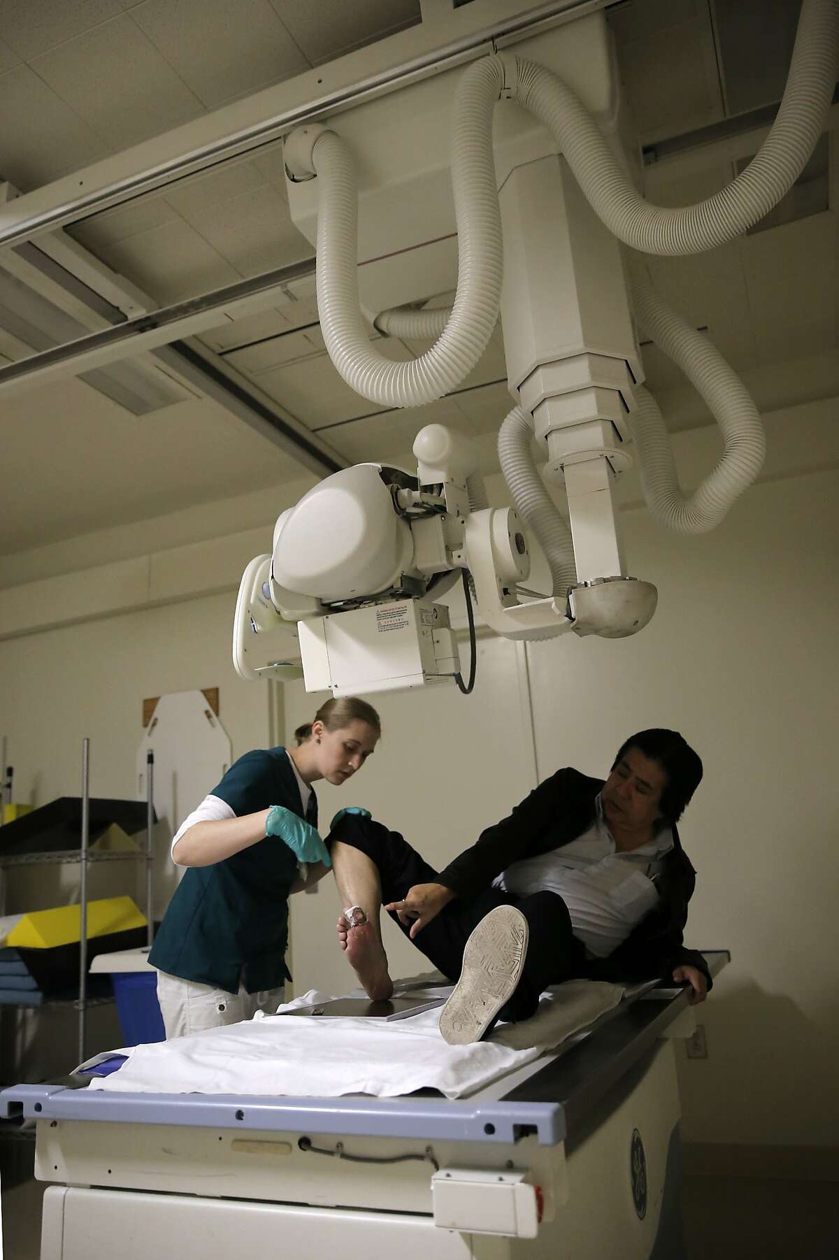 Melissa Mrizek, a student radiology technologist prepares to x-ray the foot of Luis Pimentel at Seton Medical Center, which is run by the Daughters of Charity, in Daly City Calif., as seen on Fri. March 13, 2015