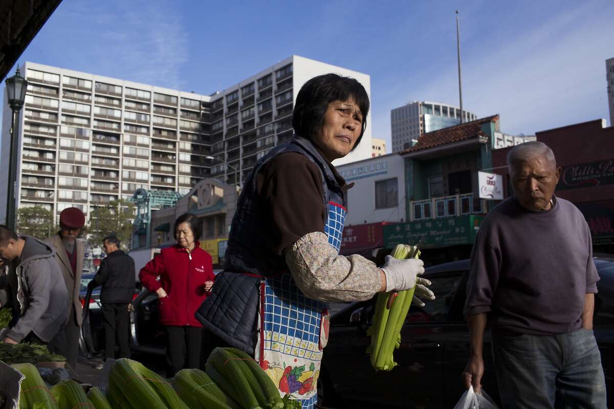 A market worker processes celery in Chinatown in Oakland, Calif. on Friday, March 13, 2015. Oakland?•s new minimum wage law has generated confusion for immigrant businesses in Chinatown, several of which have already shut down because they can?•t afford to pay employees the new rate of $12.25 per hour.