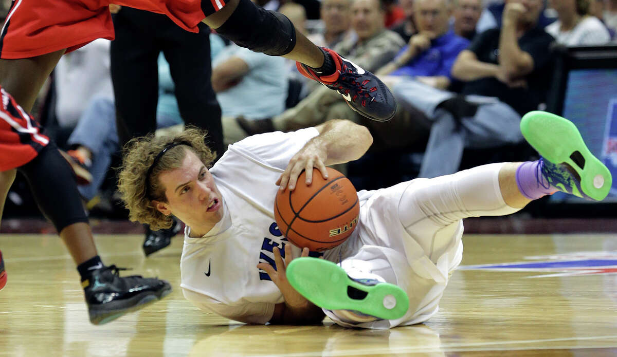 Plano West forward Mickey Mitchell grabs a loose ball and looks for a teammate as his team plays Irving MacArthur in the 6A semifinals of the UIL state basketball tournament at the Alamodome in San Antonio on March 13, 2015.