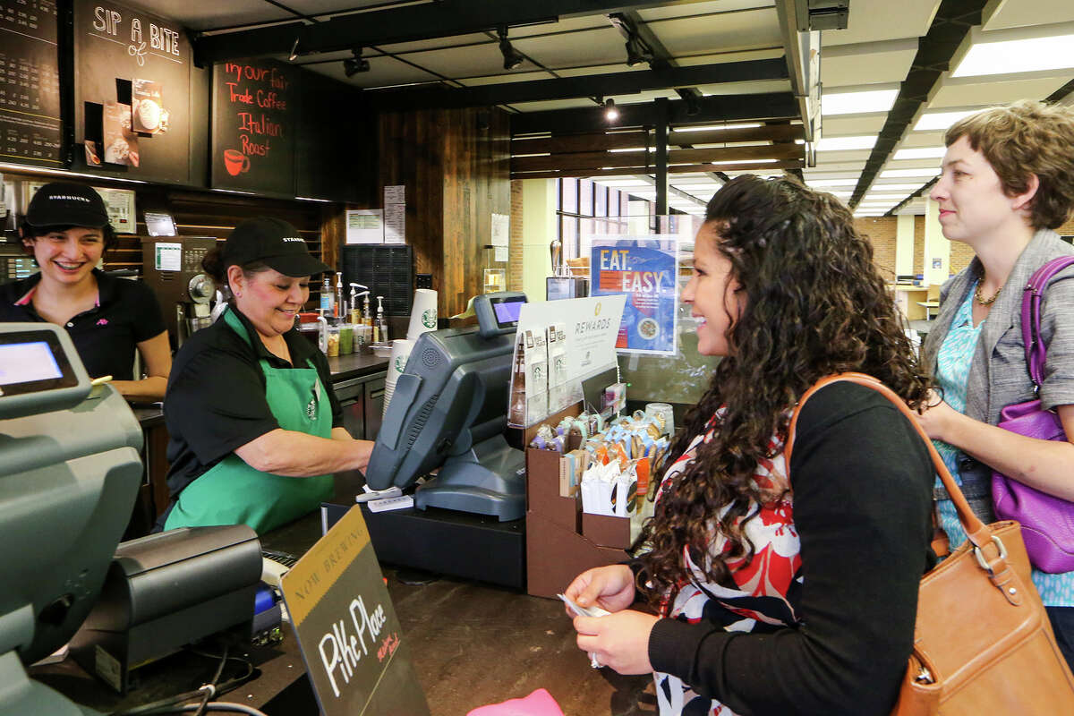 Staff facualty members Kim Kennedy (from right) and Kristen Cadena purchase coffee from cashier Margaret Contreras and Barista Ashley Shearer at the St. Mary's University Starbucks in the Louis J. Blume Library on Tuesday, March 11, 2015. St. Mary's University is working to become the first "fair trade" campus in Texas. They are currently promoting their "Fair Trade Italian Roast Coffee" advertied on the board above Contreras. MARVIN PFEIFFER/ mpfeiffer@express-news.net