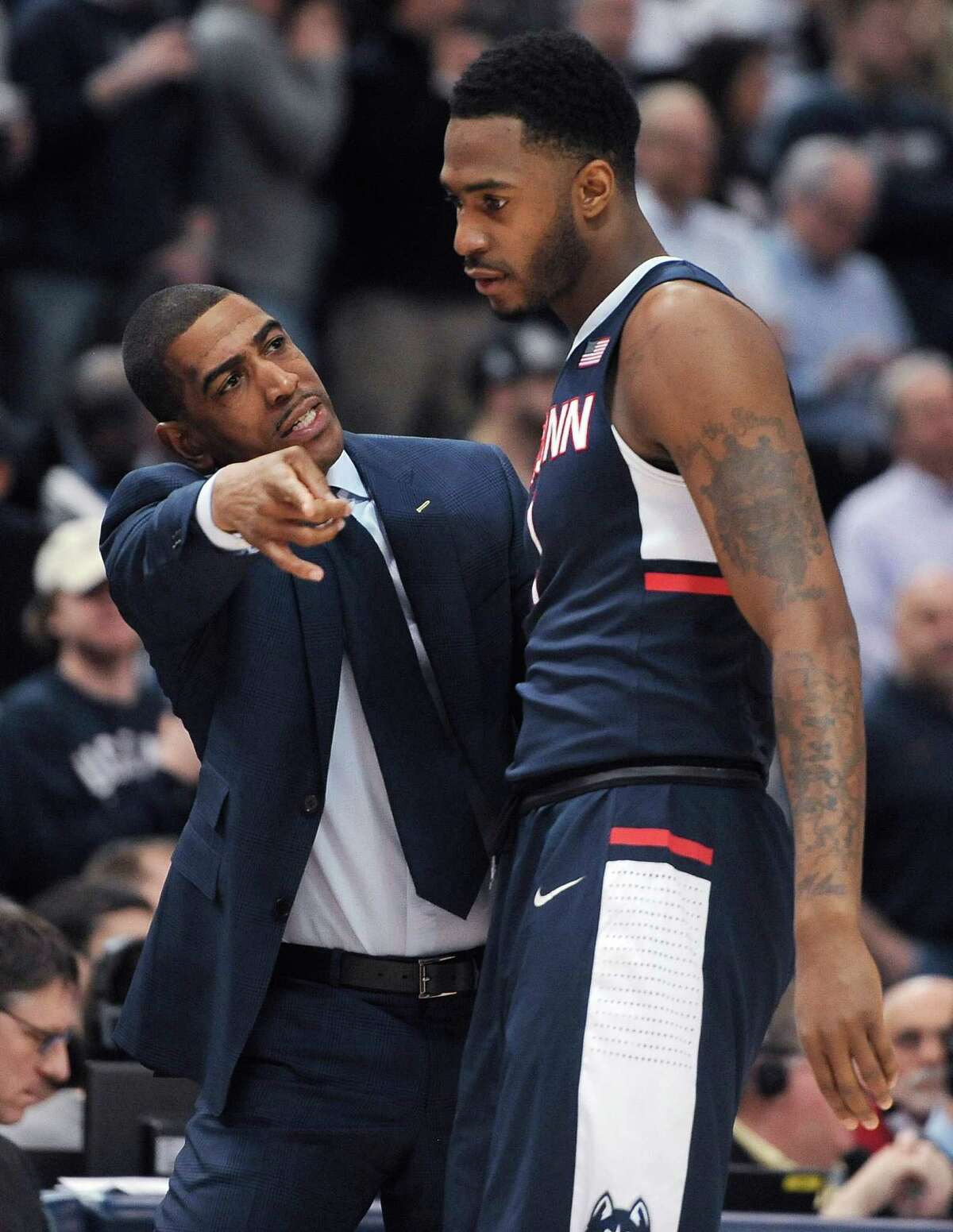 Connecticut coach Kevin Ollie talks with Phillip Nolan during the first half of an NCAA college basketball game against Cincinnati in the quarterfinals of the American Athletic Conference tournament, Friday, March 13, 2015, in Hartford, Conn.
