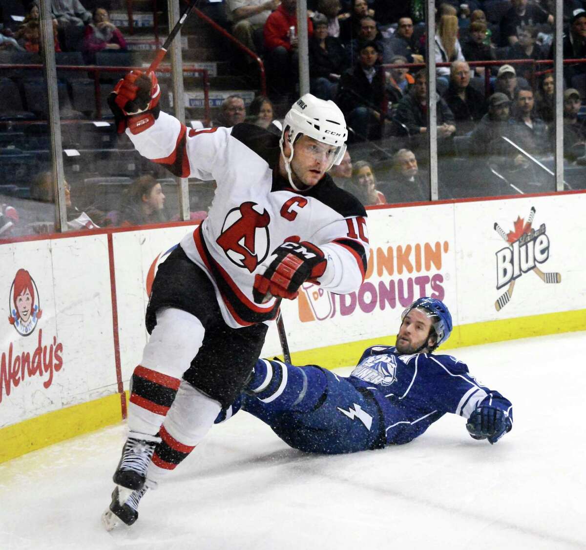 Albany Devils's # 10 Rod Pelley, left, skates away after hard check to Syracuse Crunch's #24 Jean-Philippe Cote during Saturday's game at the Times Union Center March 14, 2015 in Albany, NY. (John Carl D'Annibale / Times Union)