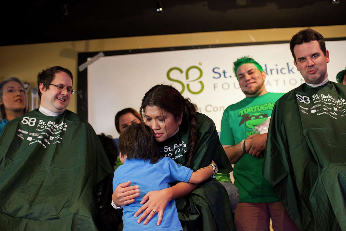 (Center) Registered nurse Christina Munoz, hugs her son Sebastian, 4, before shaving her head during St. Baldrick's Day today Saturday March 14, 2015 in San Antonio at World of Beer. Hundreds gathered from noon to 5 p.m. as monetary donations and "shavees" lined up to have their head shaved to raise money for childhood cancer research. This year they anticipated about 130 people to shave their heads, and hope to raise $100 thousand dollars for research.