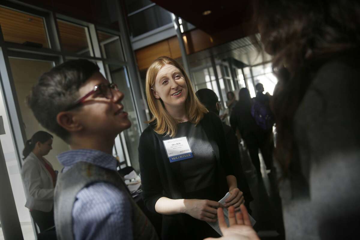 Alex Holy (center) , Mills College MBA/MPP student talks with Judi Brown (left) and Jen Gurecki (right), both with the Zawadisha Fund during The CSRB (Center for Socially Responsible Business) 7th Annual Conference at the Lorry I. Lokey Graduate School of Business at Mills College on Friday, March 13, 2015 in Oakland, California.