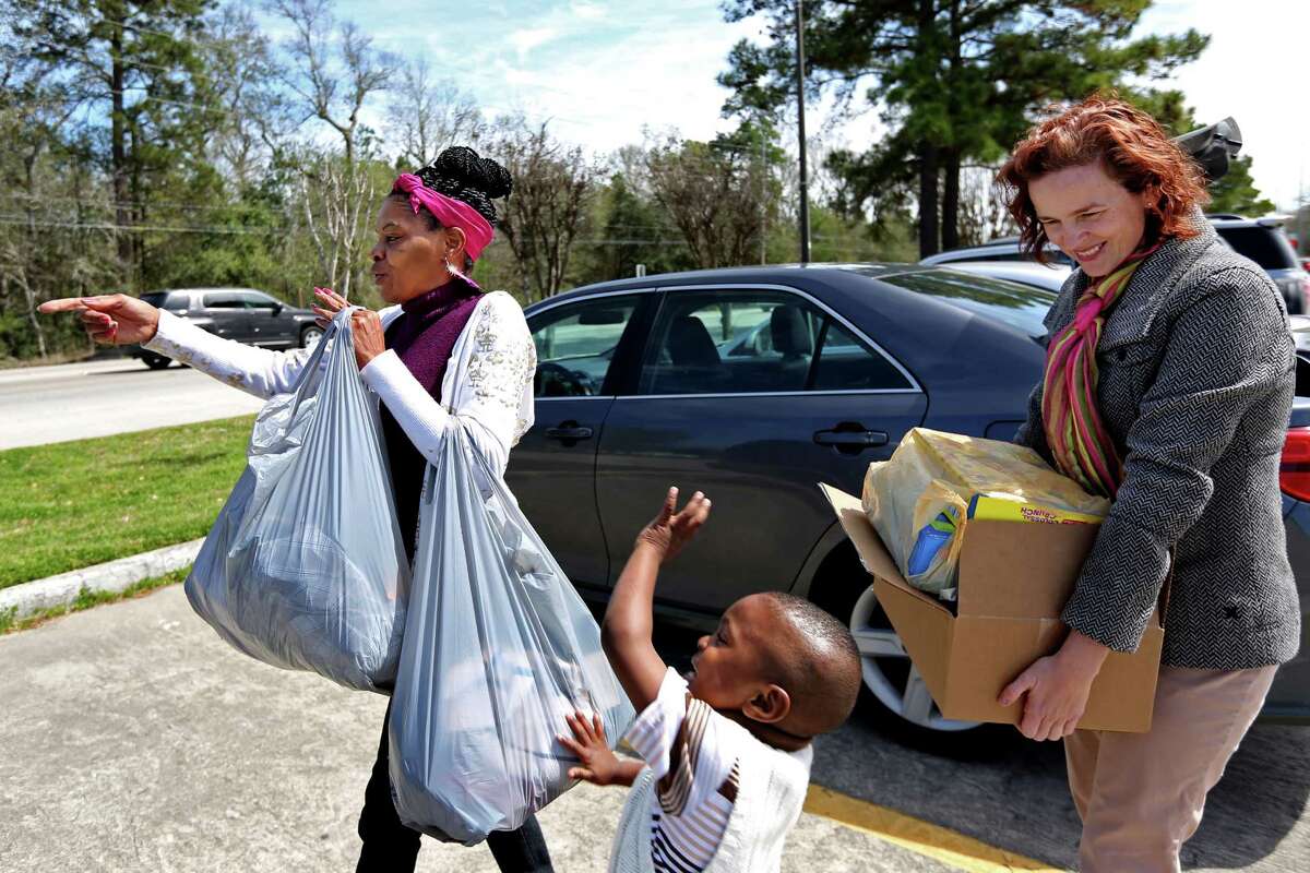 Michelle Davis, left, and Kristie Erwin, right, carry clothes and canned goods back to Davis' car that she will go to her nine children and grandchildren.﻿